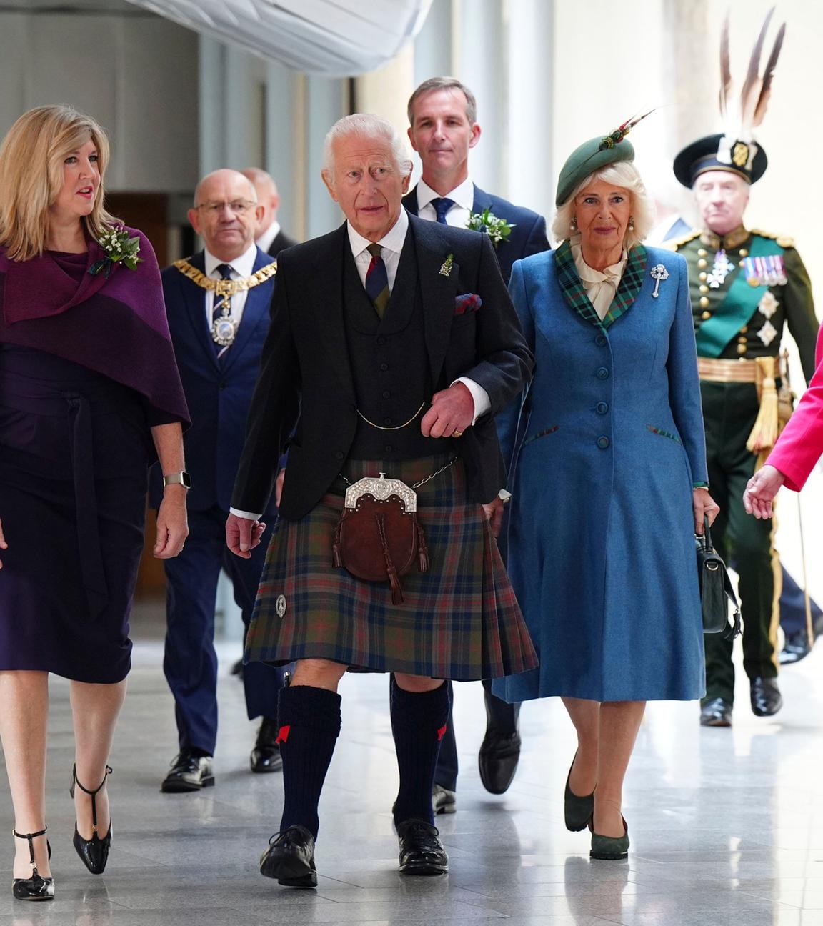 Camilla und Charles laufen im schottischen Parlament mit der Vorsitzenden Alison Johnson einen Gang entlang