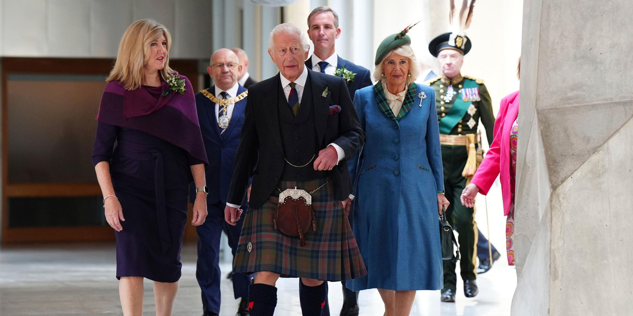 Camilla und Charles laufen im schottischen Parlament mit der Vorsitzenden Alison Johnson einen Gang entlang