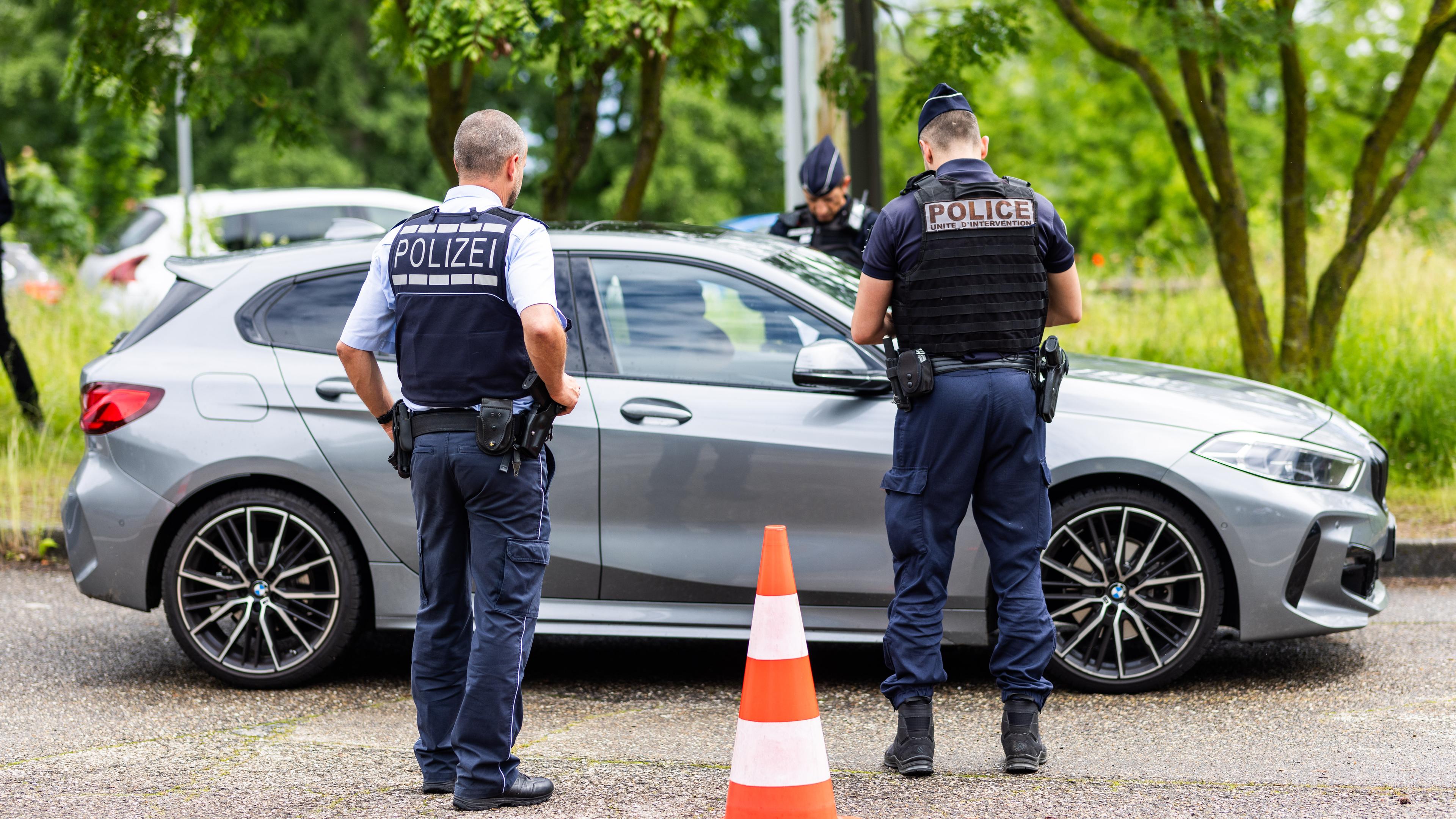 Frankreich, Straßburg: Ein Auto steht kurz hinter der deutsch-französischen Grenze auf einem Parkplatz und wird wegen der neuen Cannabis-Freigabe von Polizeibeamten beider Nationen kontrolliert.