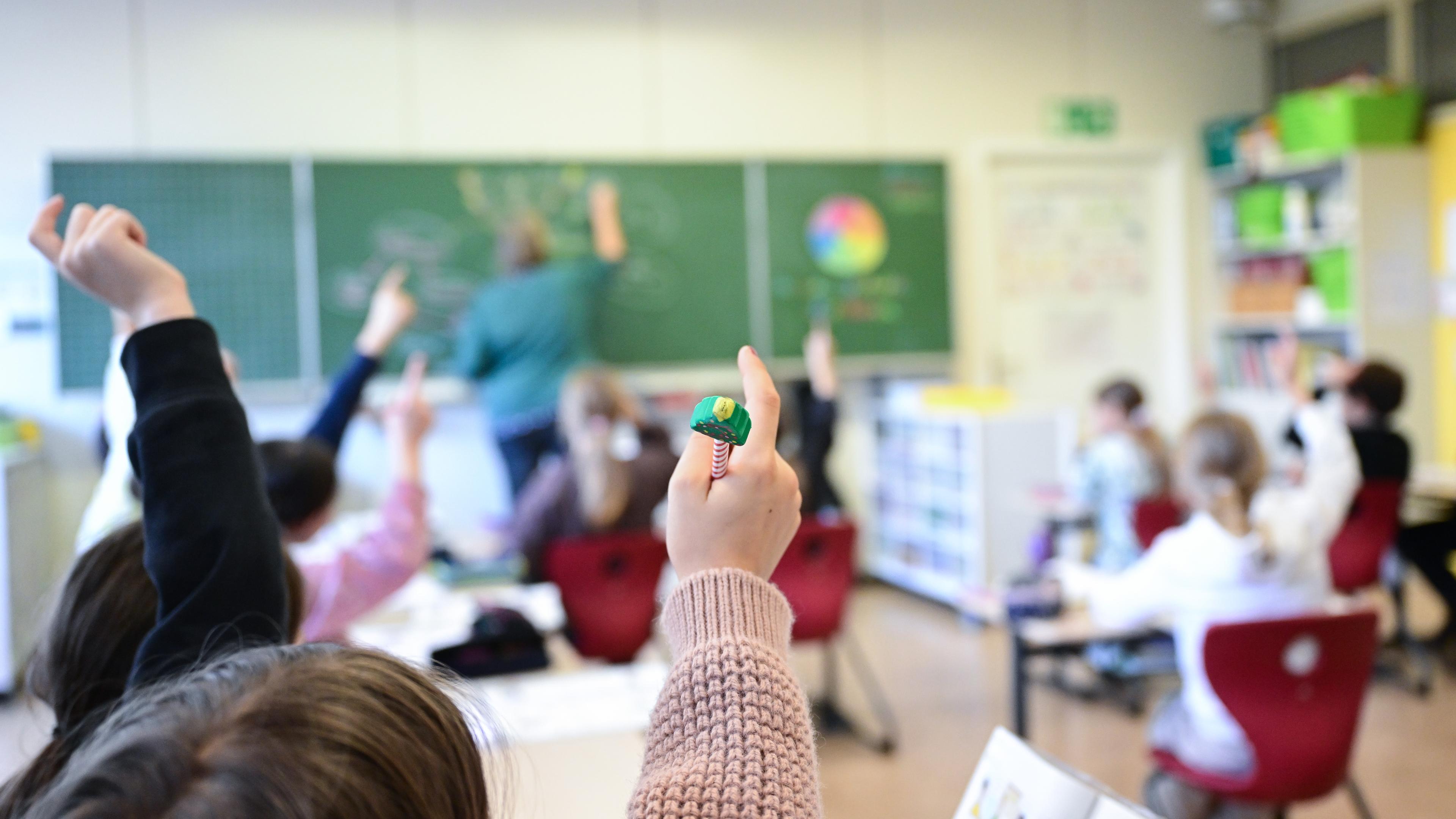 Schüler melden sich in einer vierten Klasse in einer Grundschule in Stuttgart.