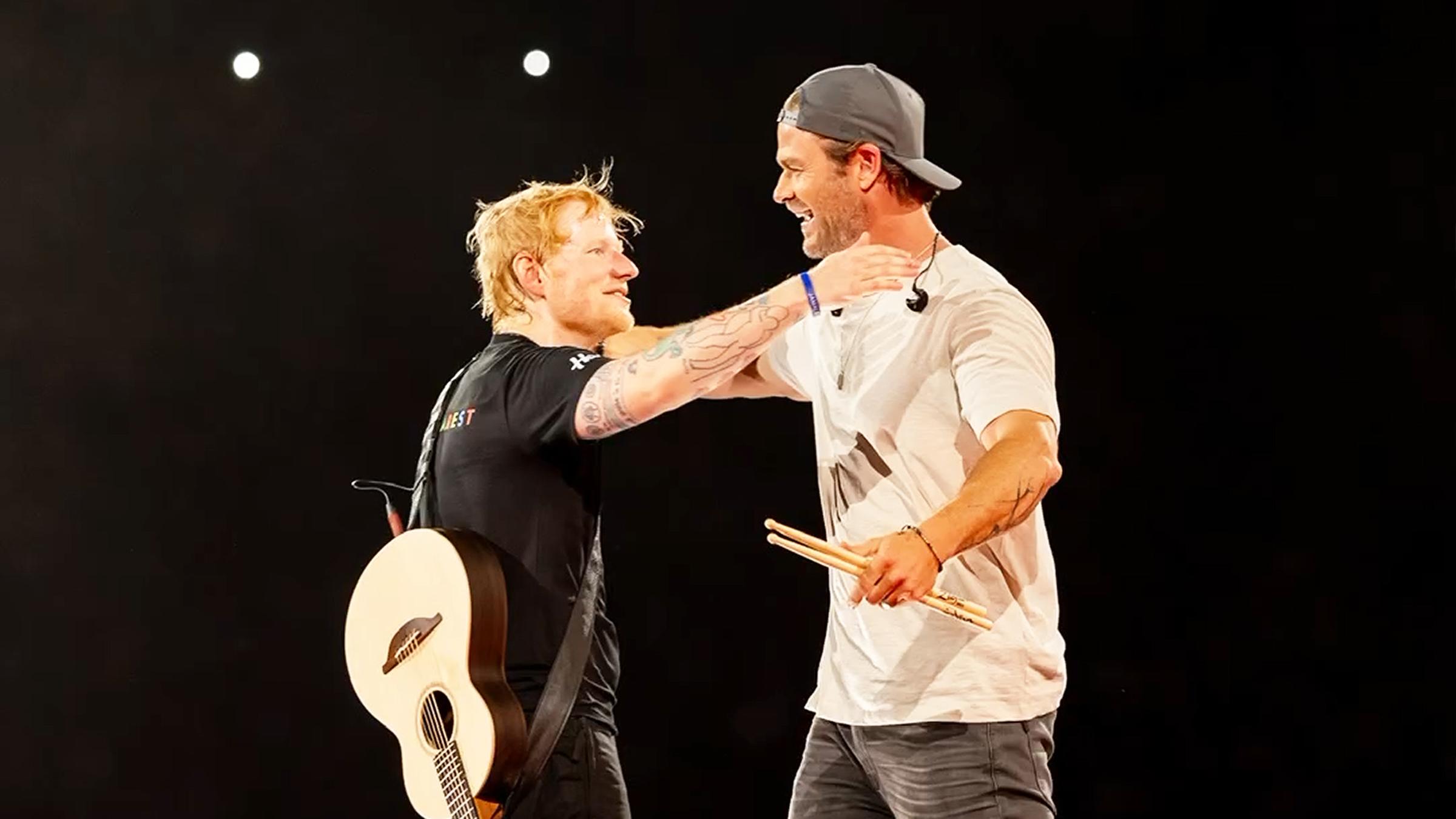 Der Sänger Ed Sheeran und der Schauspieler Chris Hemsworth umarmen sich auf der Bühne.