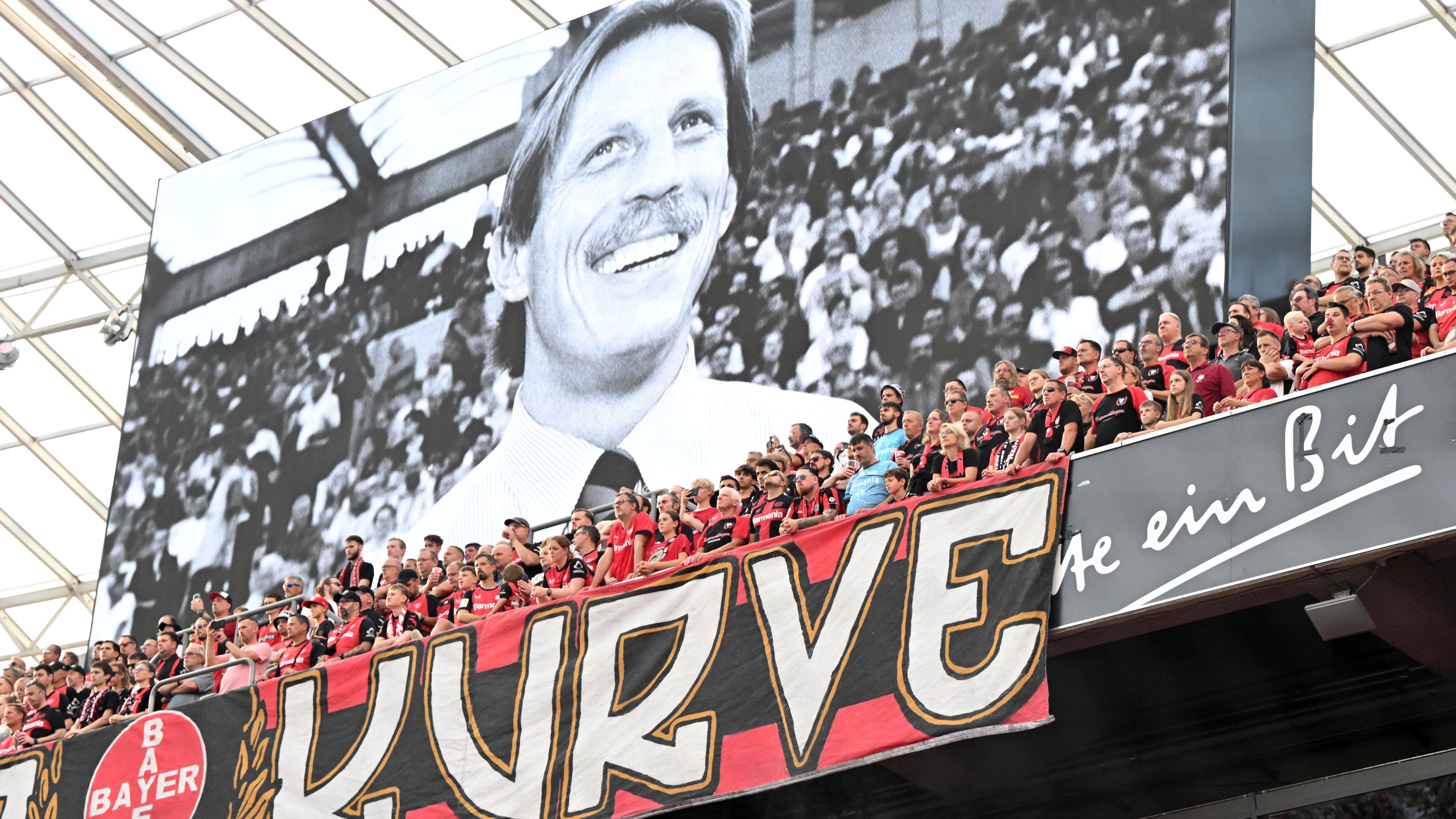 Fußball-Bundesliga 2024/25, Bayer Leverkusen - RB Leipzig, 2. Spieltag, in der BayArena: Die Fans stehen in der Kurve bei einer Gedenkminute für Christoph Daum.