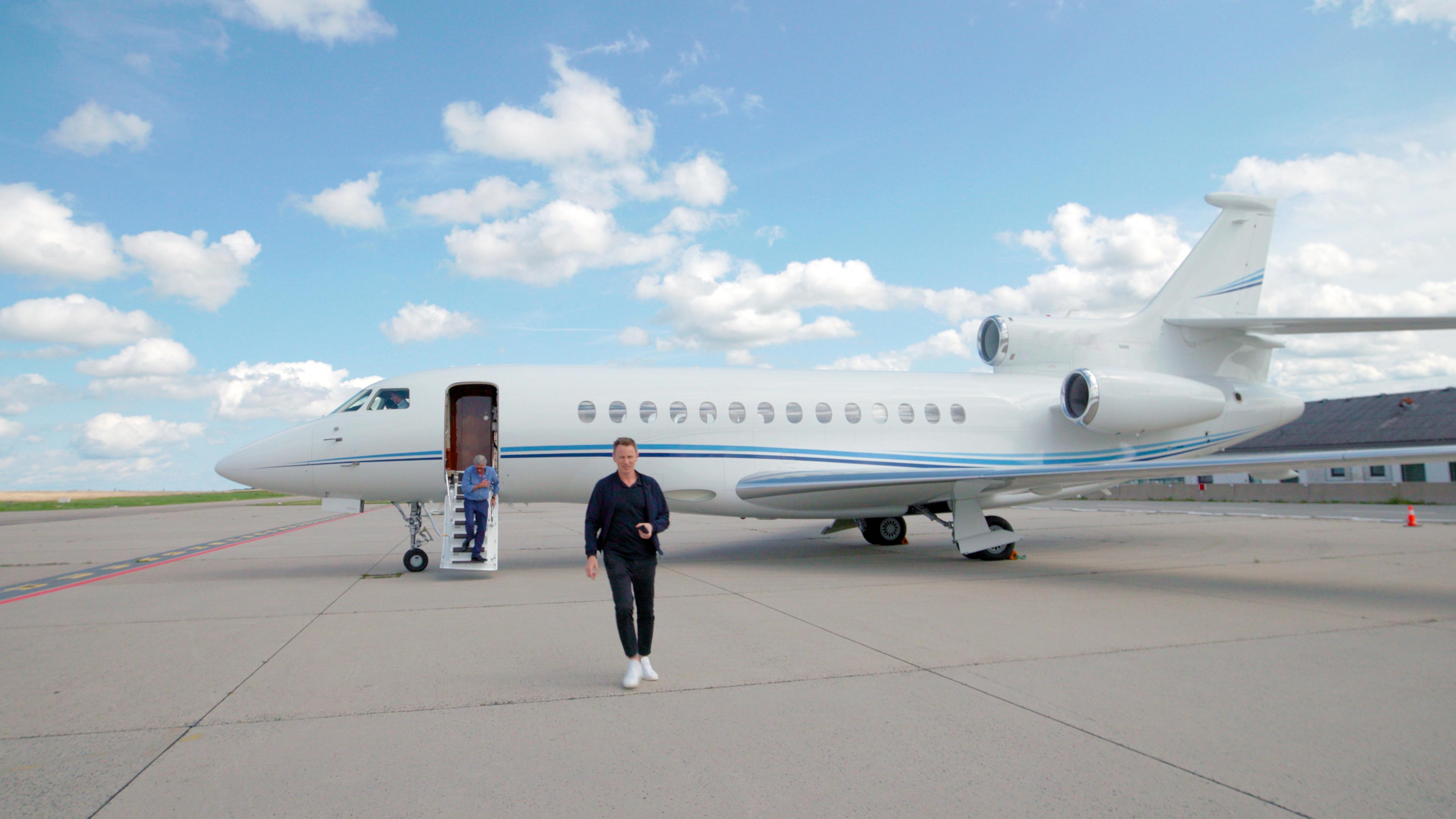  "ZDFzeit: Die geheime Welt der Superreichen - Das Milliardenspiel": Jochen Breyer läuft vor einem Jet auf einem Flughafen.