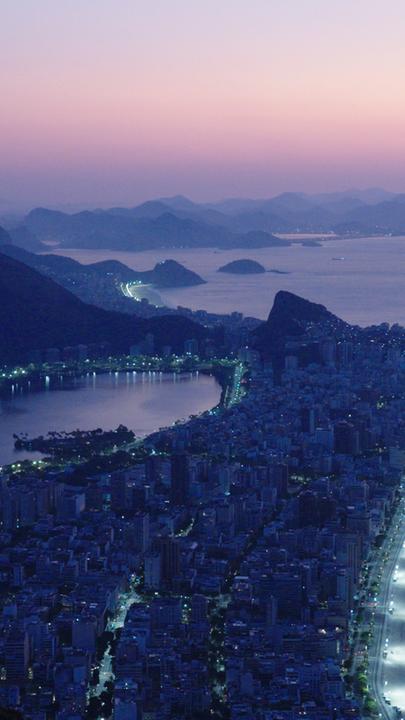 "Megacitys - Wenn es Nacht wird in Rio de Janeiro": Panoramaaufnahme: Die Lichter der Stadt Rio de Janeiro leuchten in der Morgendämmerung.