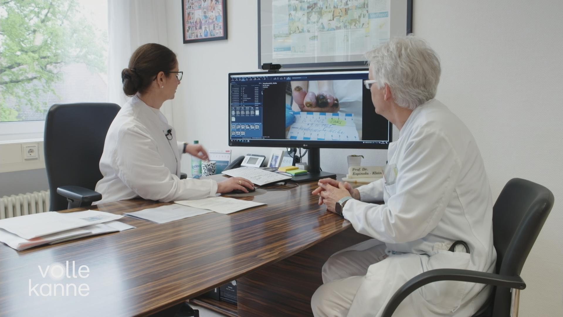 Ärztin und Patientin schauen auf einen Computer-Bildschirm
