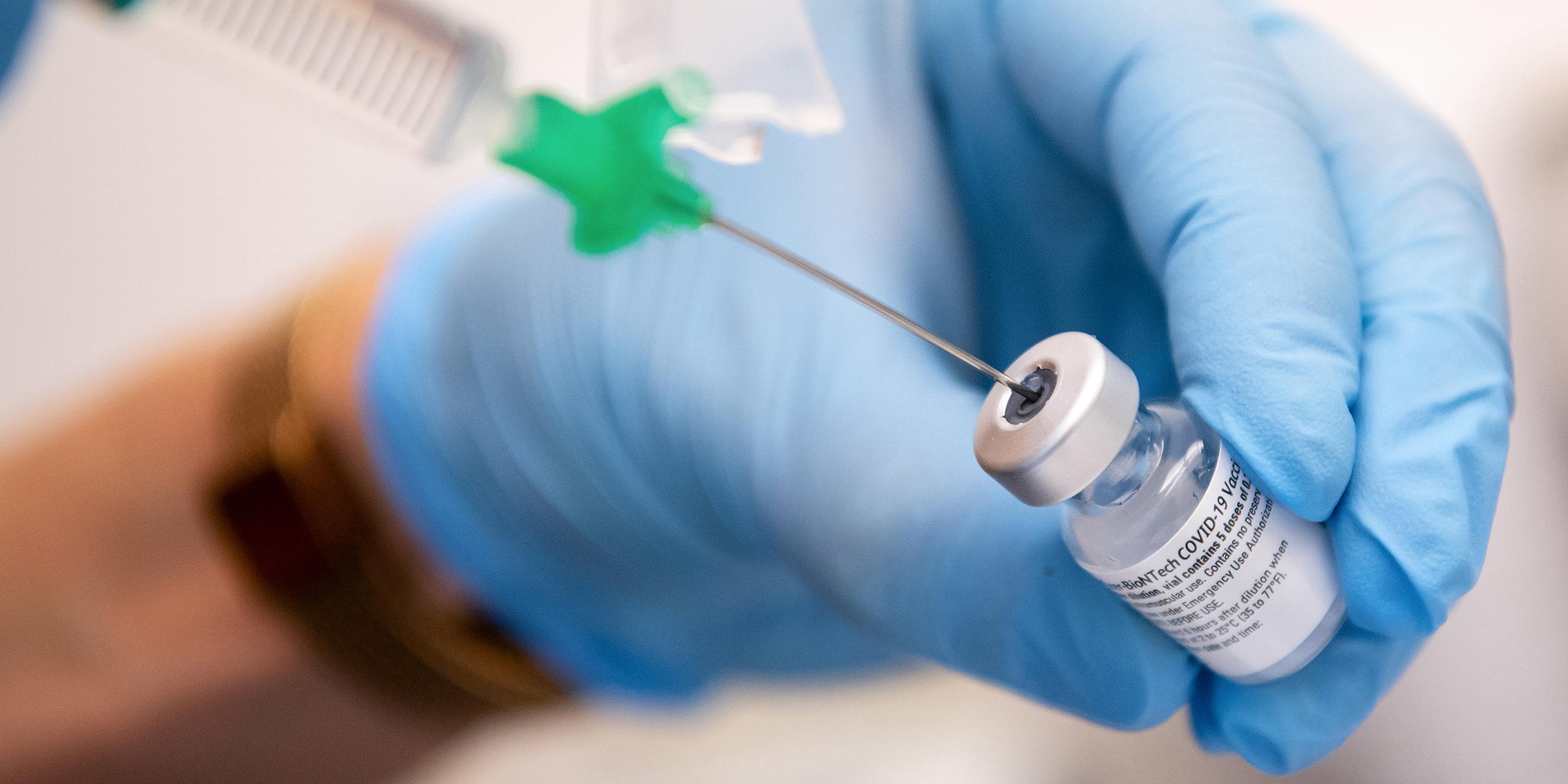  Bayern, Gauting: Eine Klinik-Mitarbeiterin zieht den Covid-19 Impfstoff von Biontech/Pfizer für eine Impfung auf eine Spritze. Archivbild