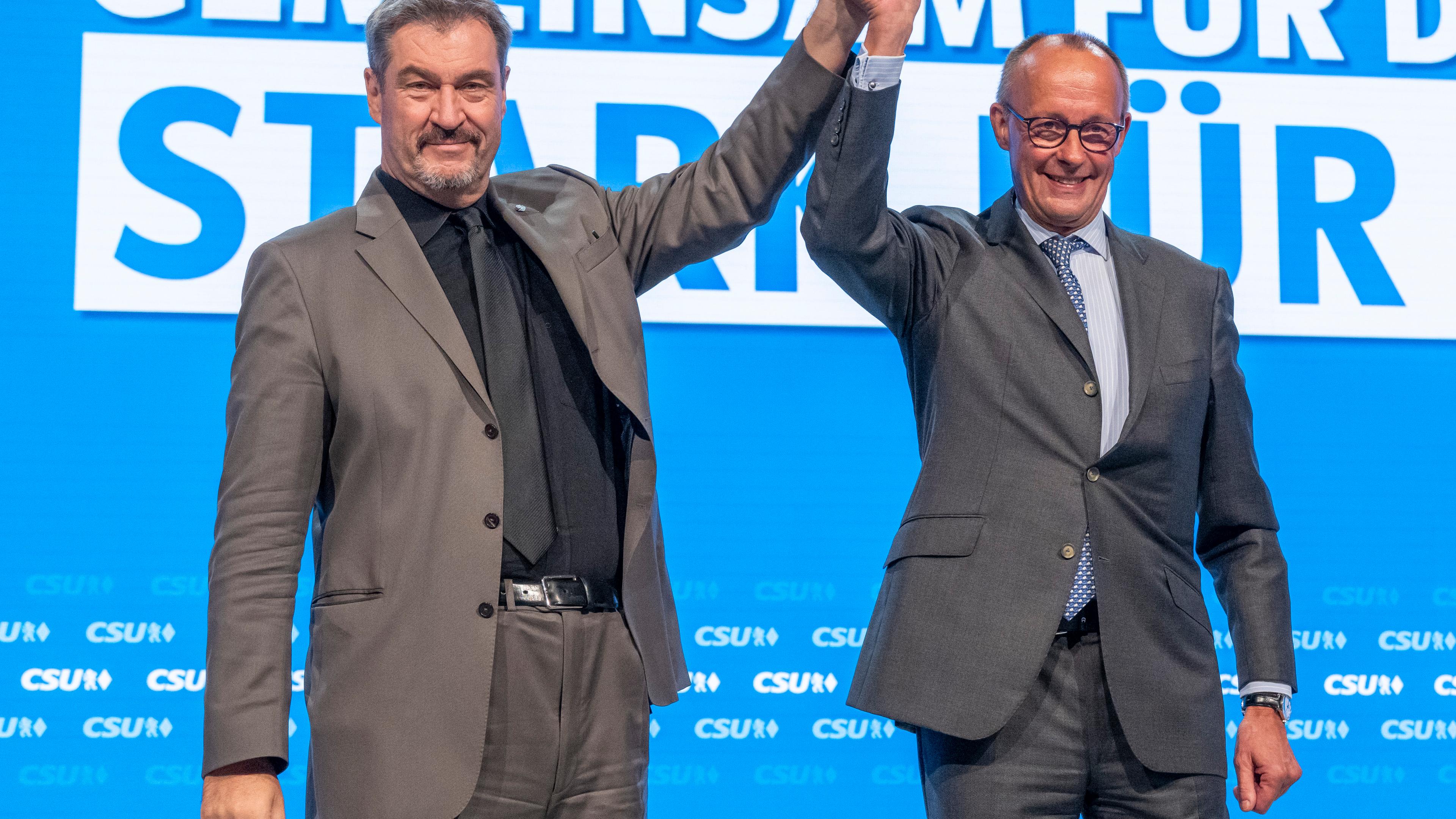 Bayern, Augsburg: Friedrich Merz (r), CDU-Bundesvorsitzender und Unionsfraktionsvorsitzender, und Markus Söder, Vorsitzender der CSU, stehen auf dem Parteitag der CSU zusammen auf der Bühne.