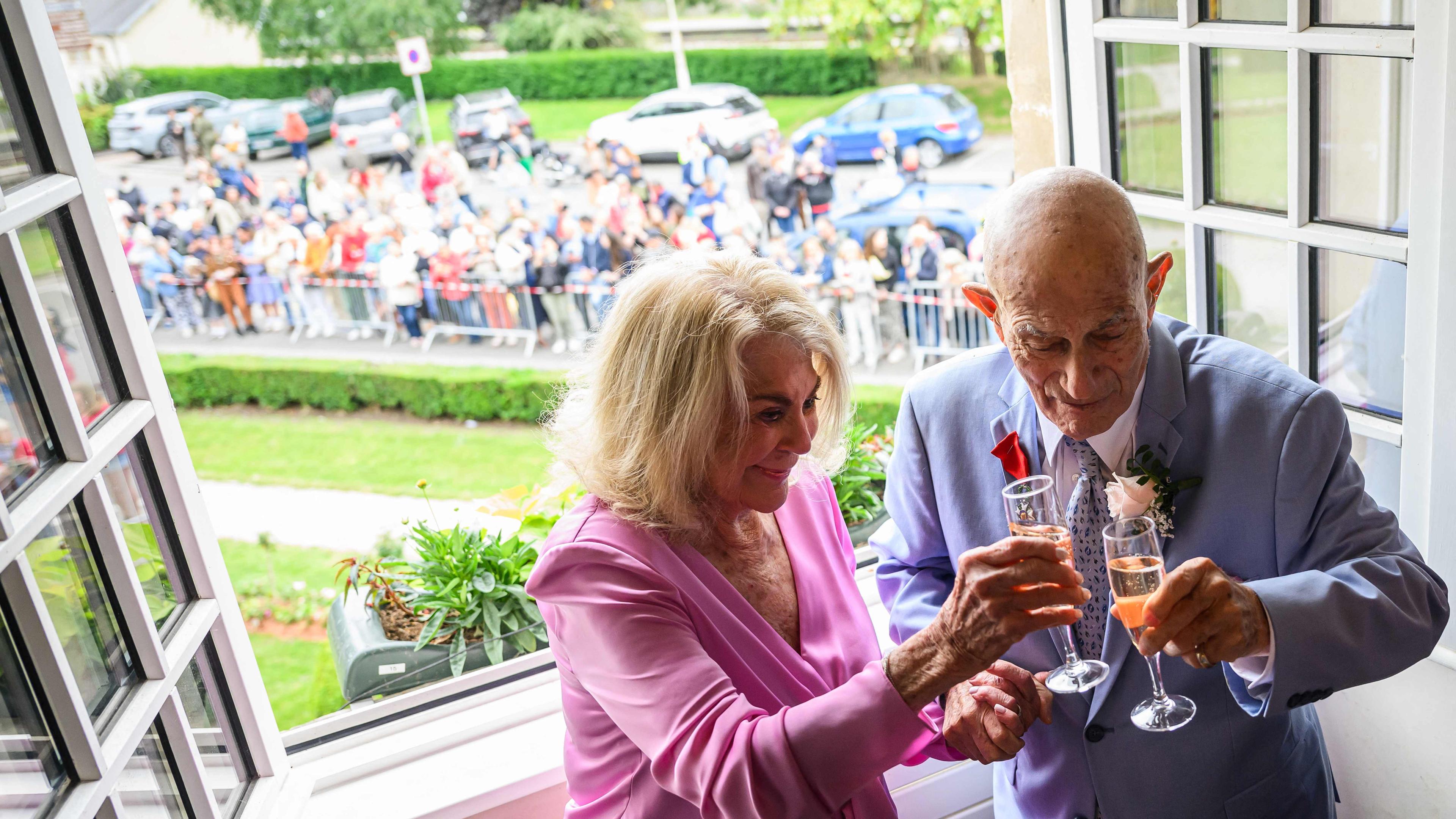 Jeanne Swerlin, 96, links, und, der US-Kriegsveteran Harold Terens, 100, rechts, stoßen mit einem Glas Champagner auf ihre Hochzeit in der Normandie an.