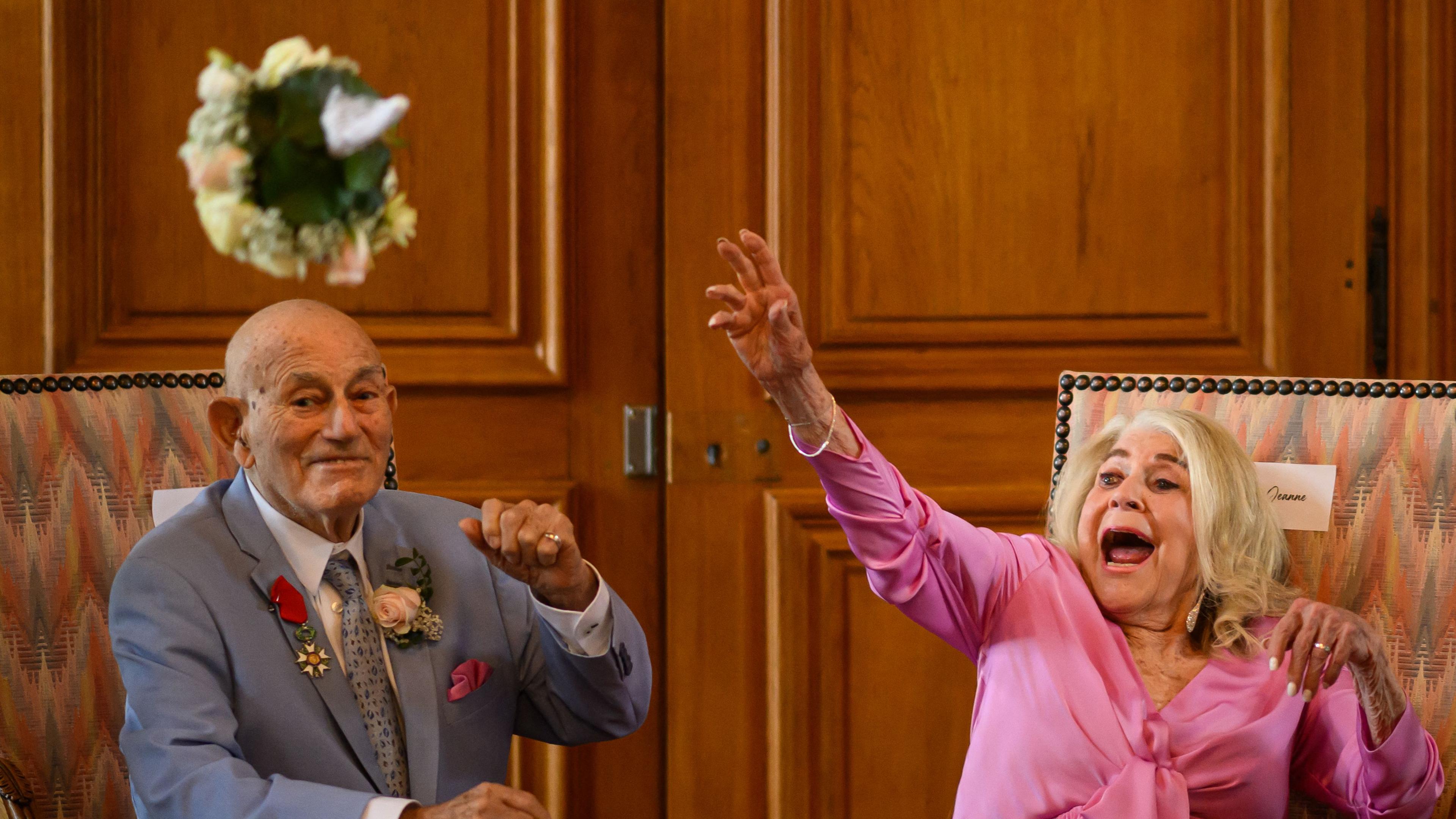 Jeanne Swerlin, 96, links, und, der US-Kriegsveteran Terens, 100, haben im Rathaus von Carentan-les-Marais, Normandie geheiratet - zwischen ihnen fleigt der Brautstrauß.