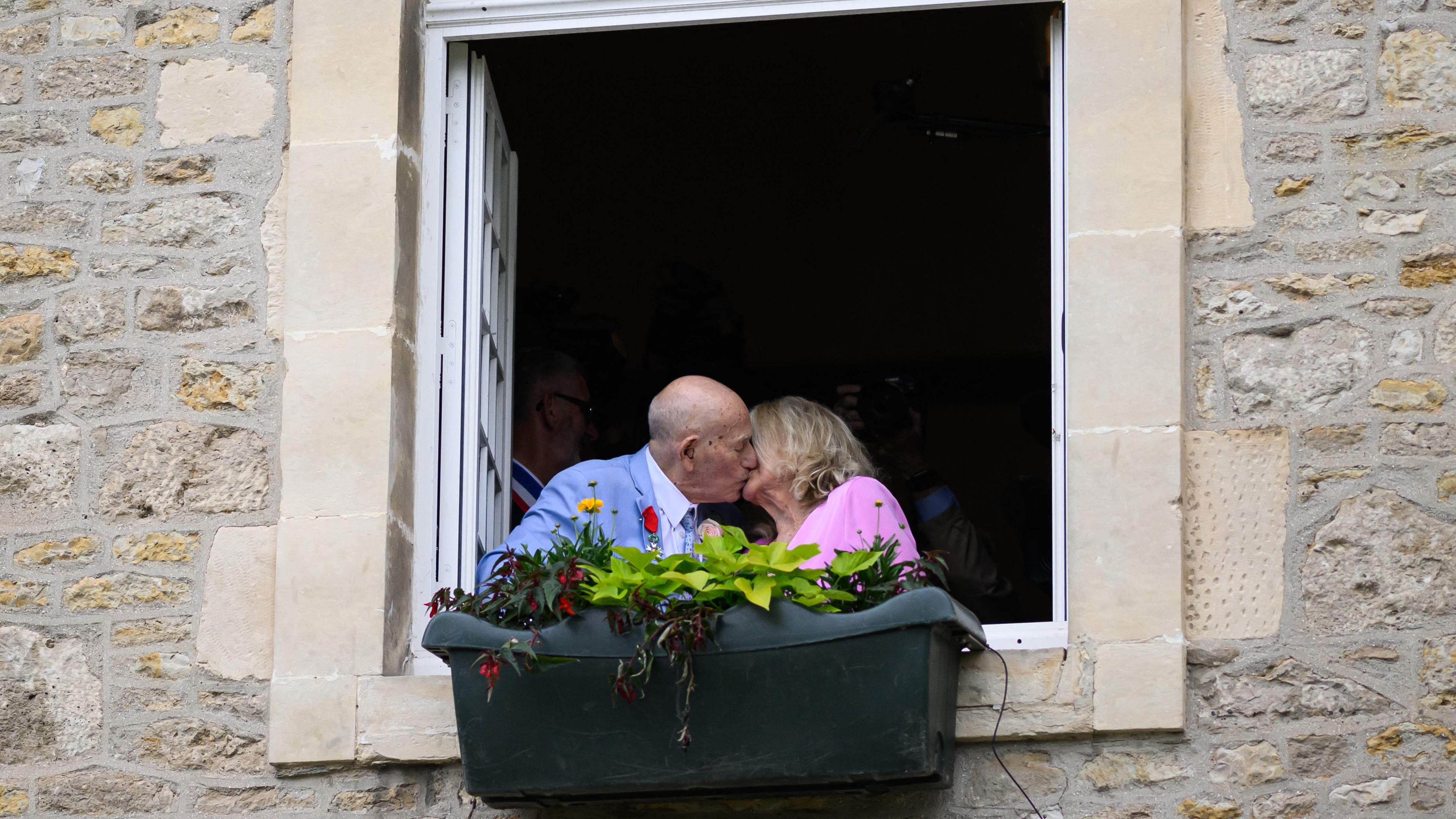 US-Kriegsveteran Terens, 100, links, und Jeanne Swerlin, 96, rechts, küssen sich am Fenster nach ihrer Hochzeit in der Normandie, 80 Jahre nach dem D-Day.