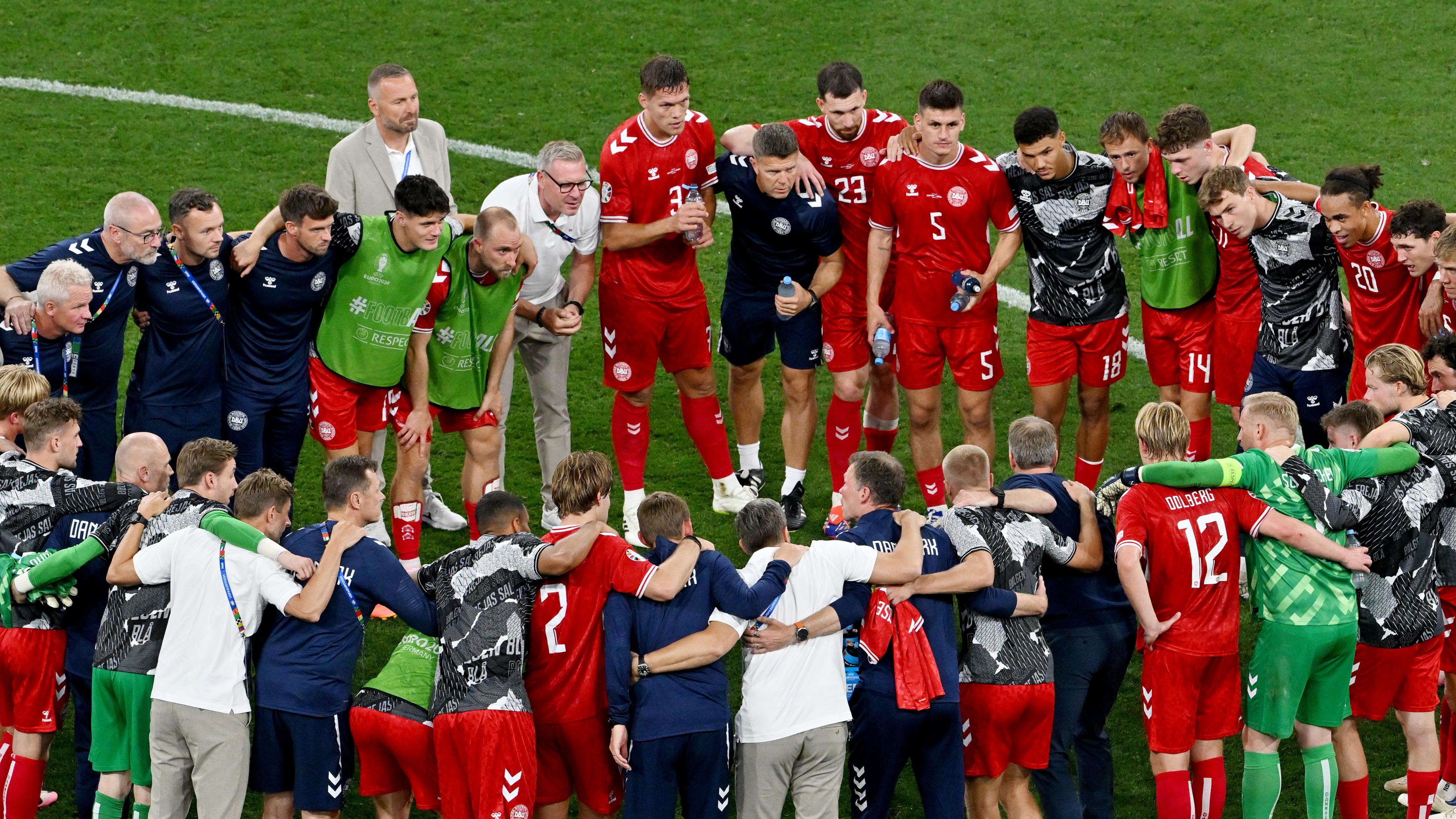 Die Spieler, Trainer und Betreuer der dänischen Nationalmannschaft stehen nach dem Spiel gegen Serbien in einem Teamkreis zusammen. 