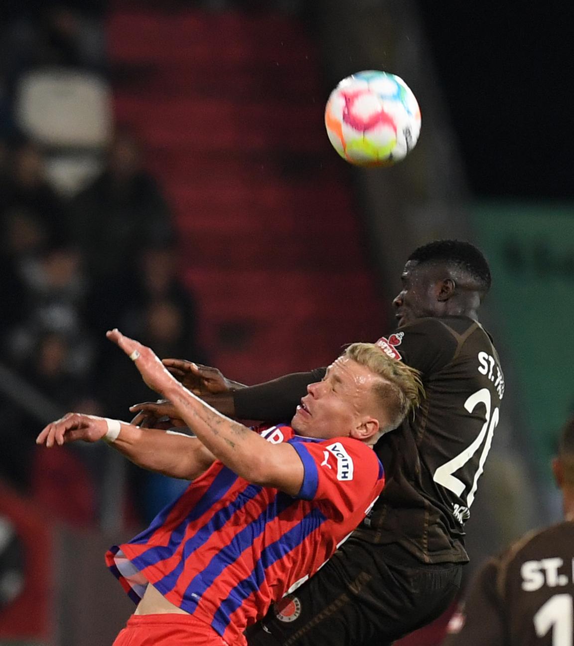 01.10.2022, Hamburg: Fußball, 2. Bundesliga, 10. Spieltag: FC St. Pauli - 1. FC Heidenheim im Millerntor-Stadion. Heidenheims Lennard Maloney (l.) und Hamburgs Afeez Aremu kämpfen um den Ball.