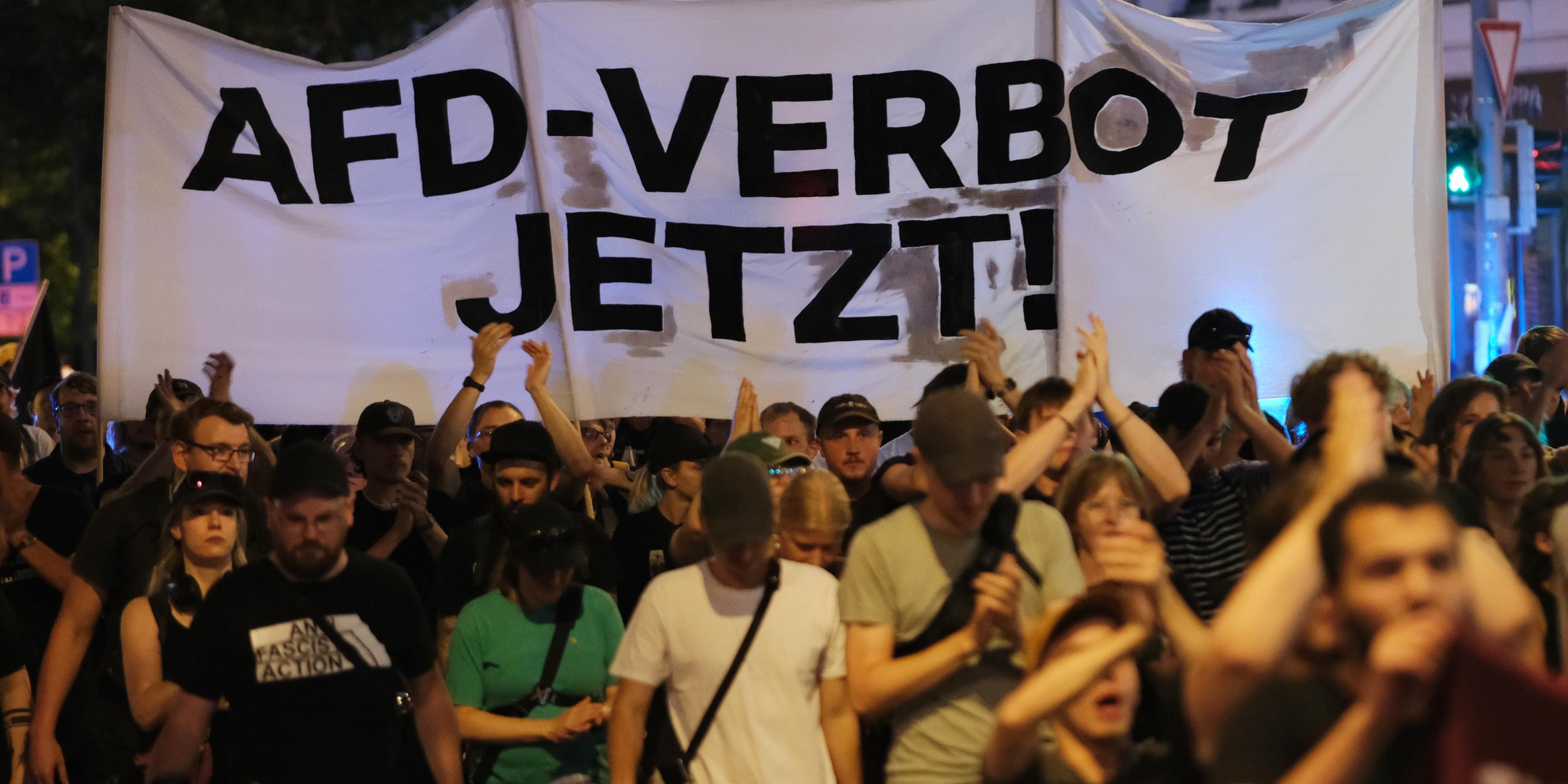 Sachsen, Leipzig: Teilnehmer einer linken Demonstration gehen mit Transparent mit der Aufschrift "AfD-Verbot jetzt!" eine Straße entlang. 