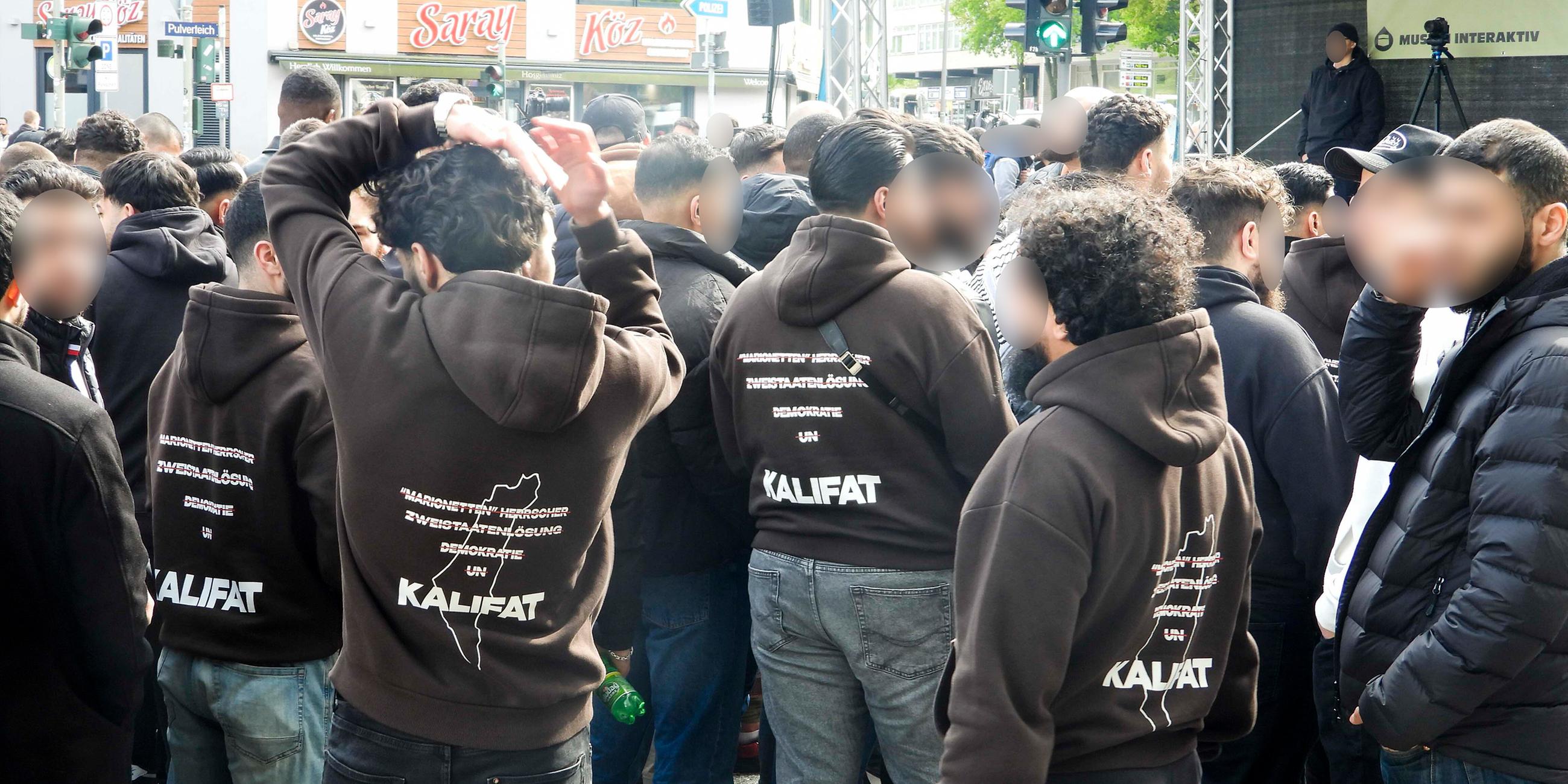 Demonstranten traten für Kalifat ein , auf ihren Jacken Mehrere hundert Demonstranten mit weissen Fahnen Spruchbaendern Plakaten bei der Muslimaktiv Demonstration am Hamburger Steindamm