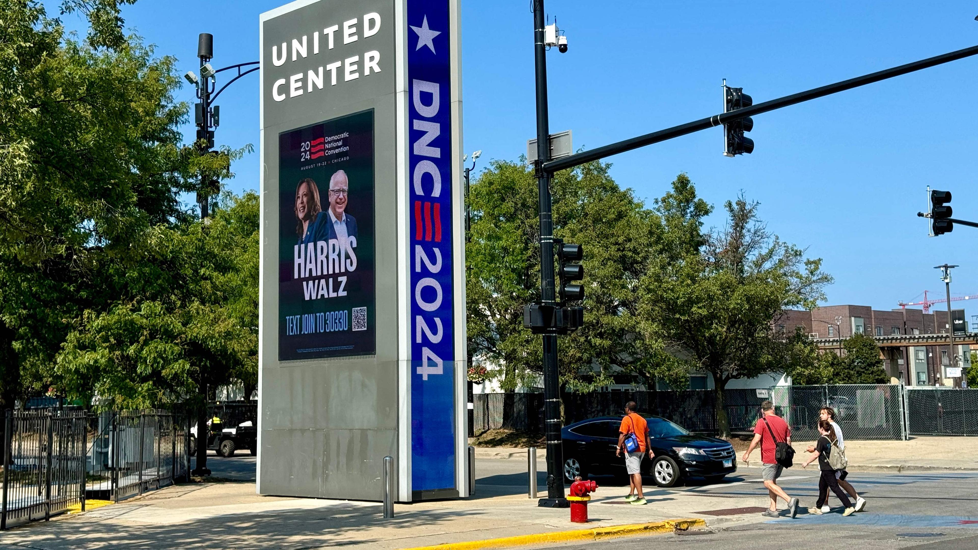 Menschen gehen vor dem Parteitag der Demokraten an einem Harris-Walz-DNC-Schild in der Nähe des United Center in Chicago, Illinois, vorbei. 