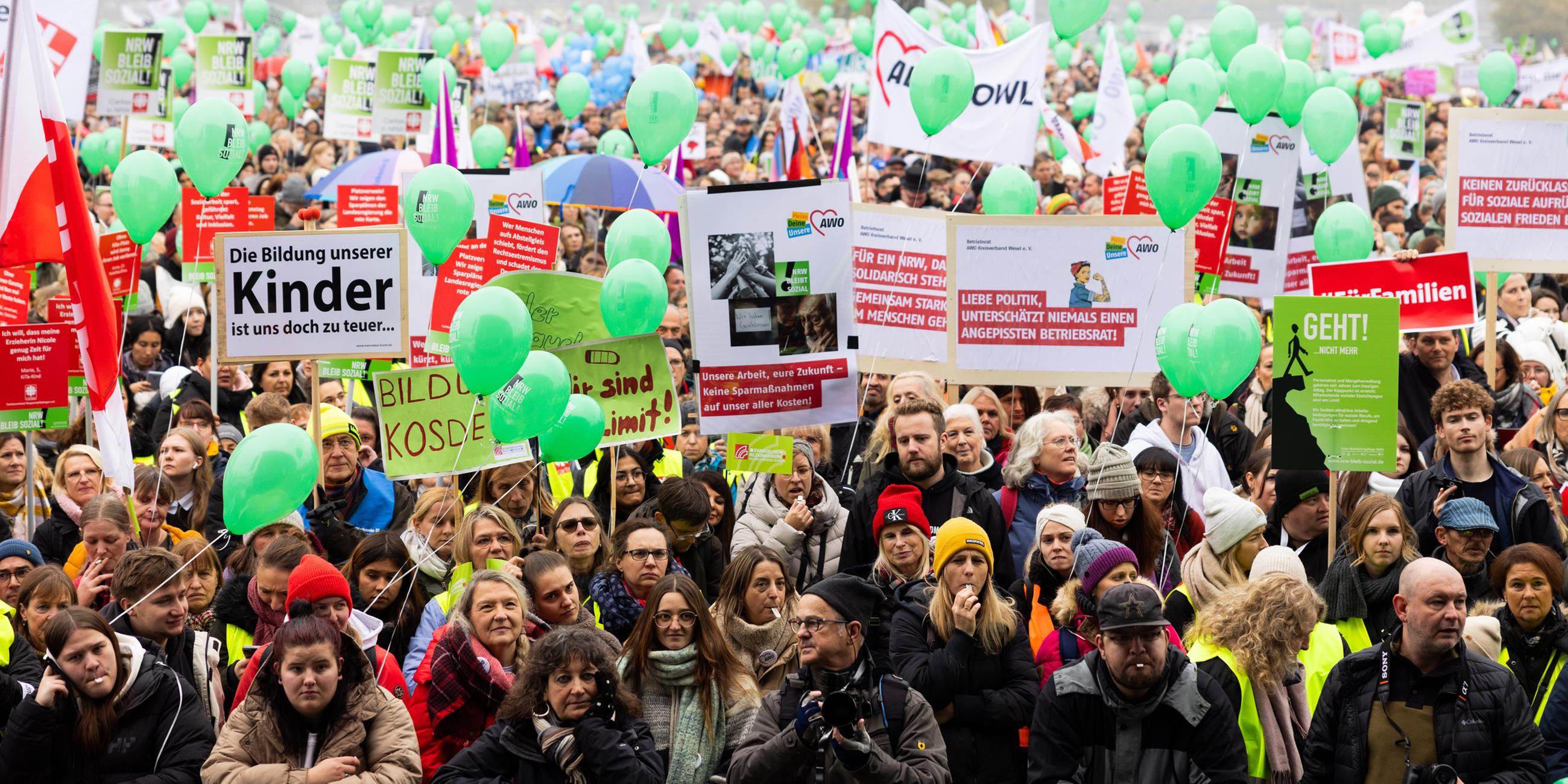  Menschen versammeln sich zu einer Kundgebung von Wohlfahrtverbänden gegen geplante Kürzungen der Landesregierung auf den Oberkasseler Rheinwiesen.