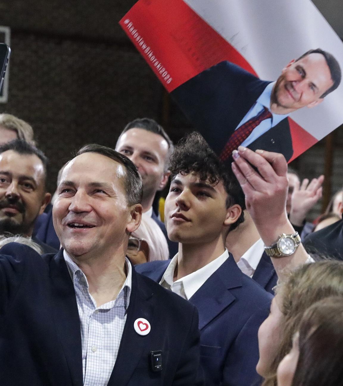 Der polnische Außenminister Radoslaw Sikorski (Mitte) von der Regierungspartei Bürgerplattform posiert für ein Selfie während seines Treffens mit Anwohnern in Pruszkow, Zentralpolen, 17. 11. 2024.