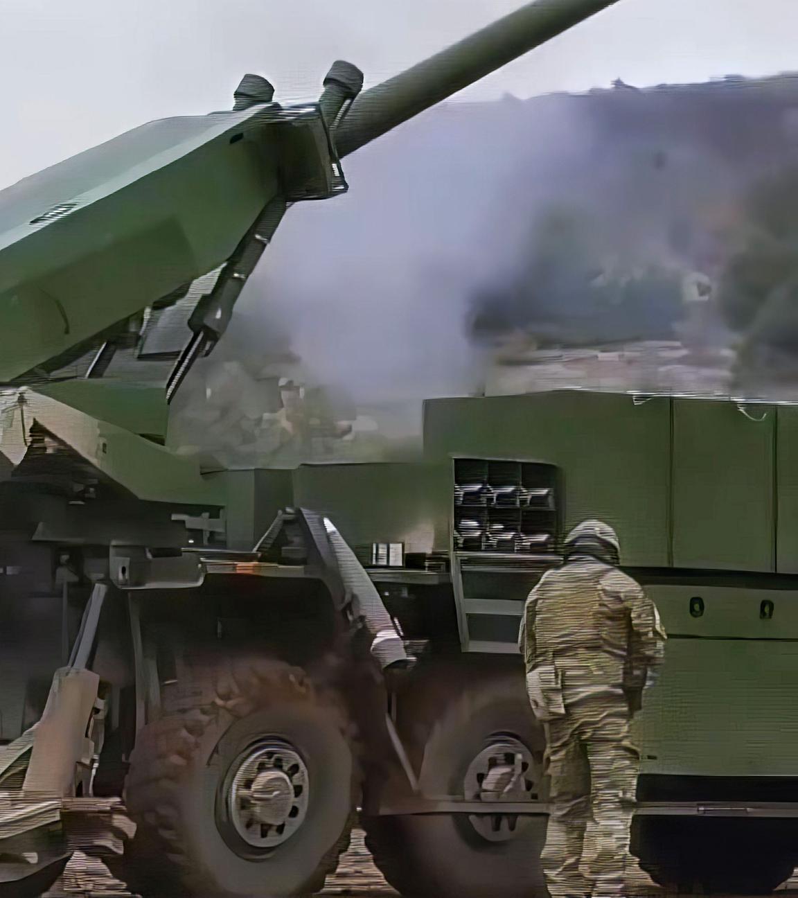 Ein Flugabwehrpanzer steht im Rauch einer abgeschossenen Rakete, daneben stehen mehrere Soldaten.