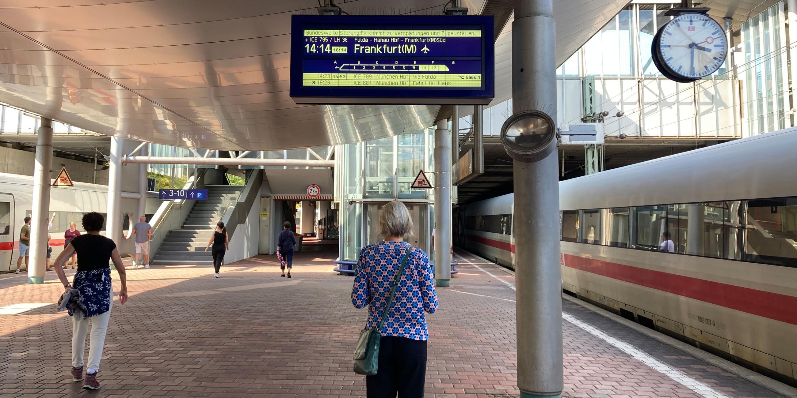 07.09.2024, Kassel: Ein Frau steht auf dem Bahnsteig und schaut sich eine Anzeige der Deutsche Bahn an. Foto: Verena Schmitt-Roschmann/dpa +++ dpa-Bildfunk +++; No data!