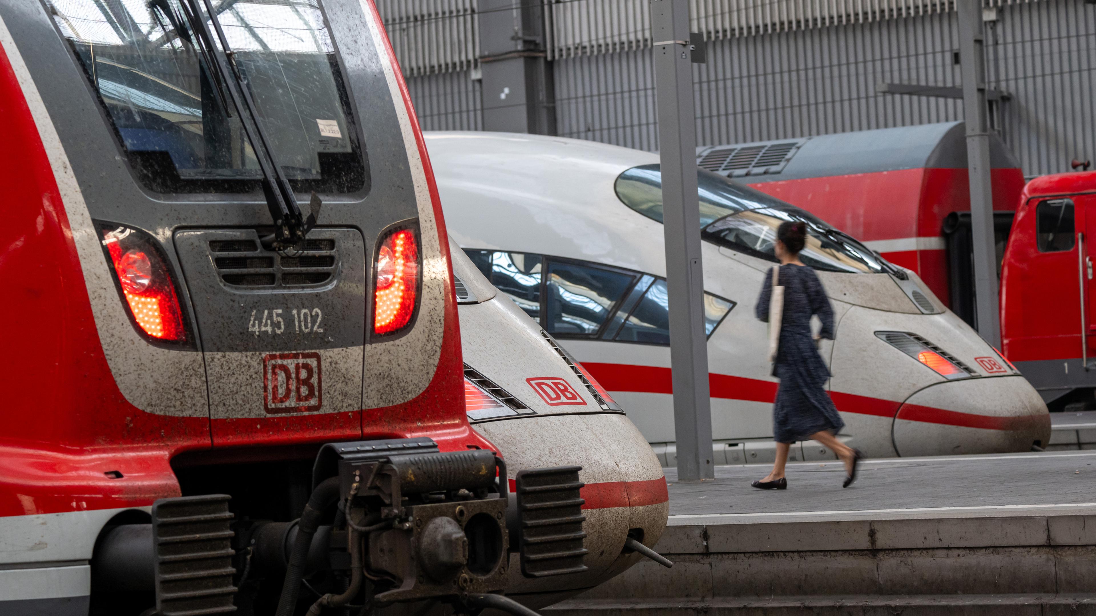 Bayern, München: Zugreisende gehen an Zügen der Deutschen Bahn im Münchner Hauptbahnhof vorbei.