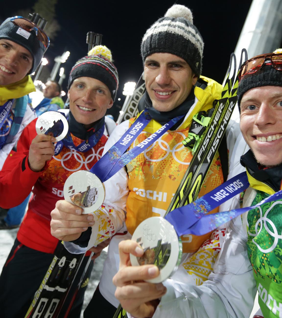 Russland, Krasnaja Poljana: Die Silbermadaillengewinner in der Staffel im Biathlon bei den Olympischen Spielen in Sotschi, Simon Schempp (l-r), Erik Lesser, Arnd Peiffer and Daniel Boehm präsentieren ihre Medaillen