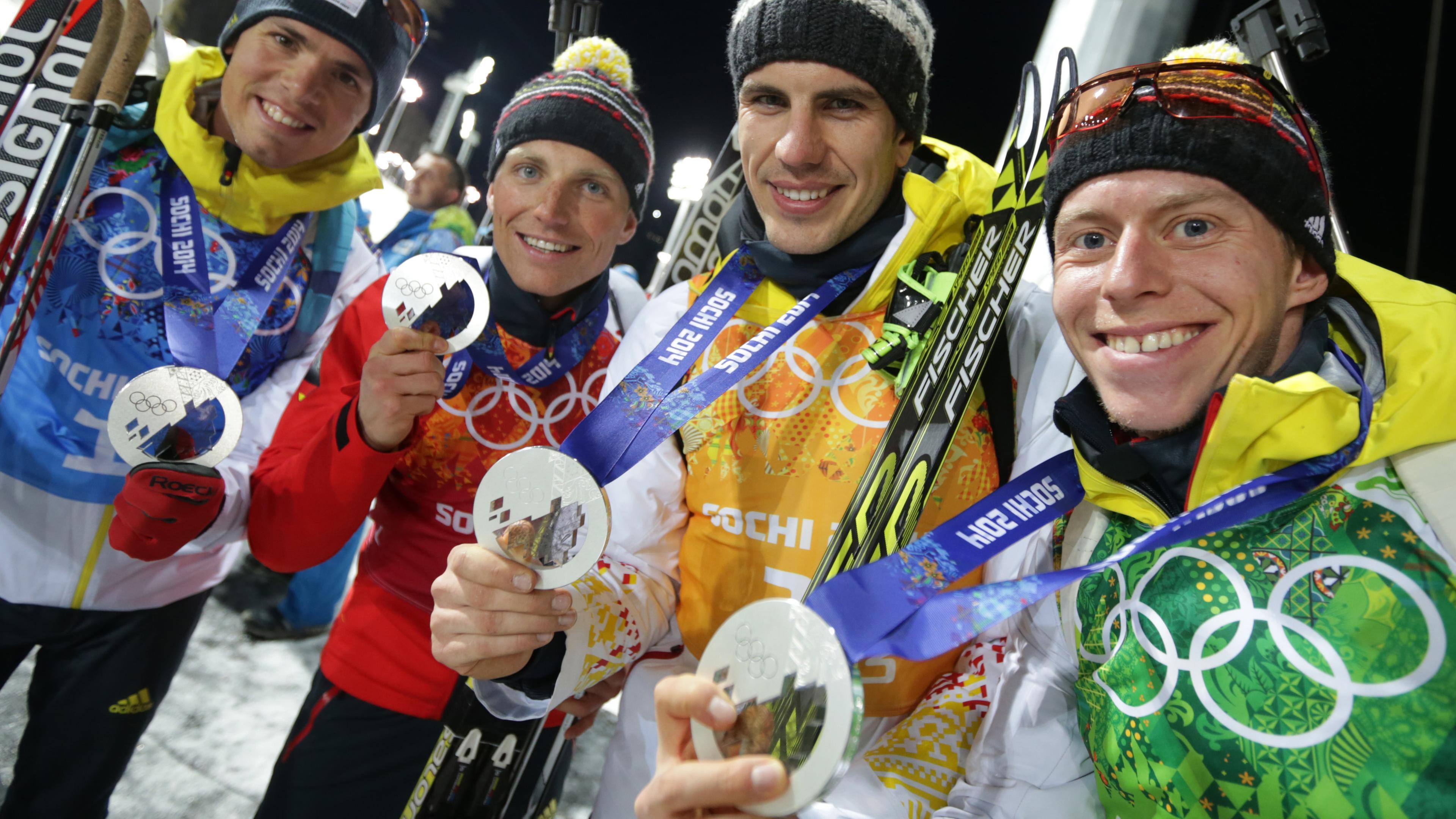 Russland, Krasnaja Poljana: Die Silbermadaillengewinner in der Staffel im Biathlon bei den Olympischen Spielen in Sotschi, Simon Schempp (l-r), Erik Lesser, Arnd Peiffer and Daniel Boehm präsentieren ihre Medaillen