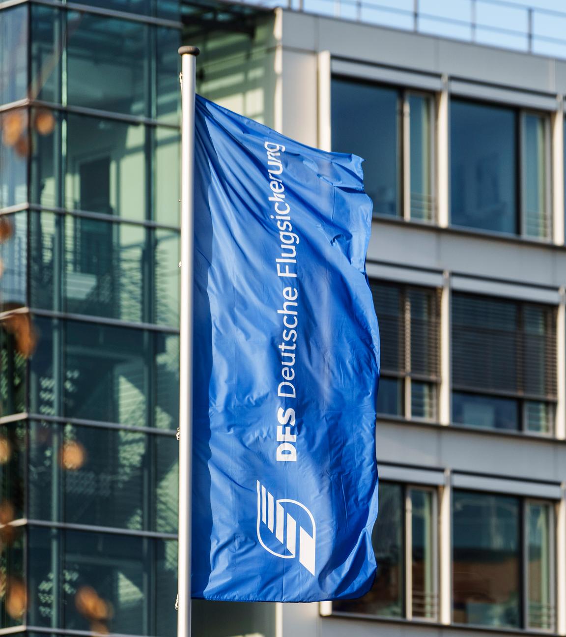 Eine Flagge mit dem Logo der Deutschen Flugsicherung flattert vor dem Hauptsitz in Langen, Hessen.