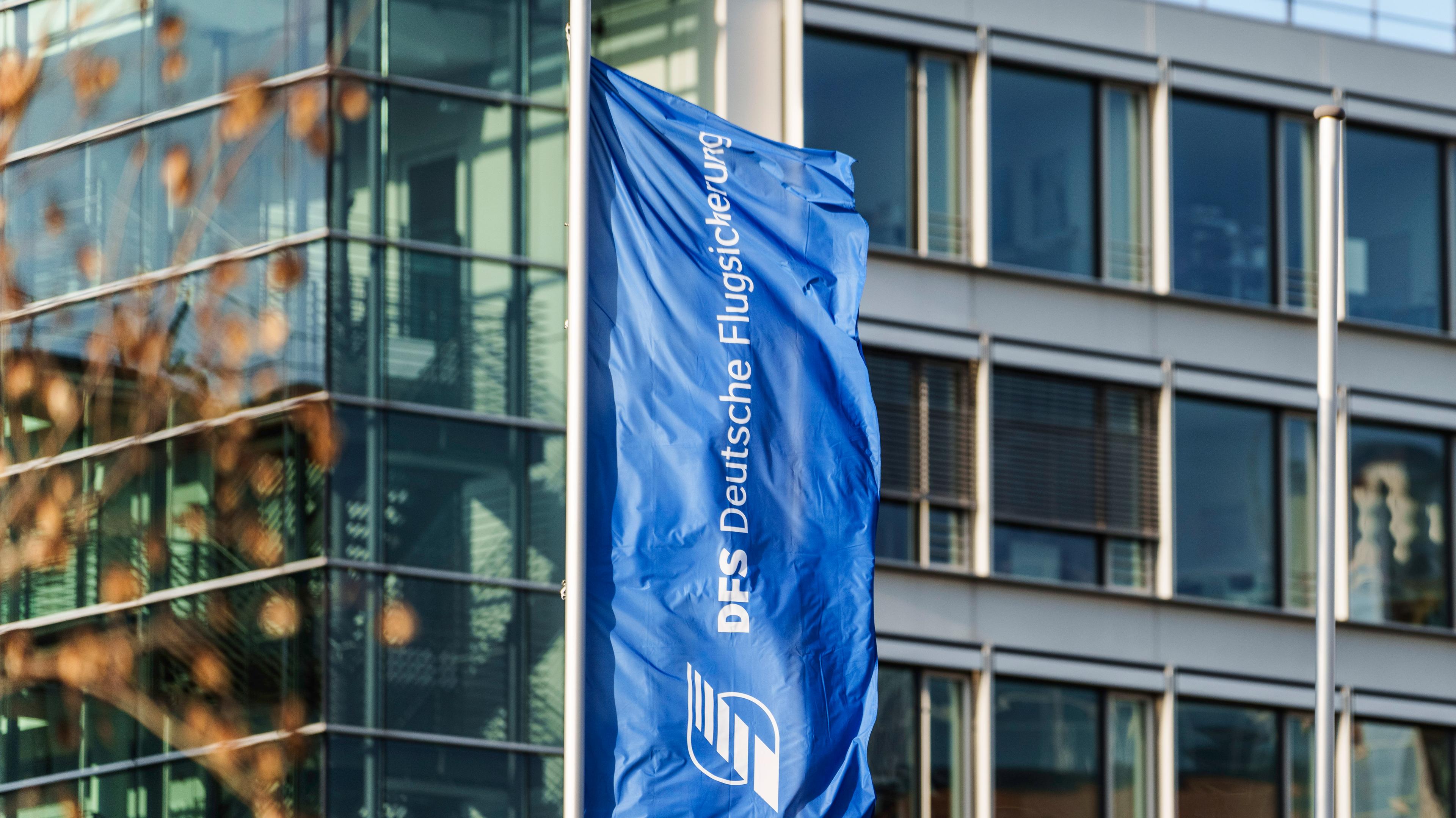 Eine Flagge mit dem Logo der Deutschen Flugsicherung flattert vor dem Hauptsitz in Langen, Hessen.