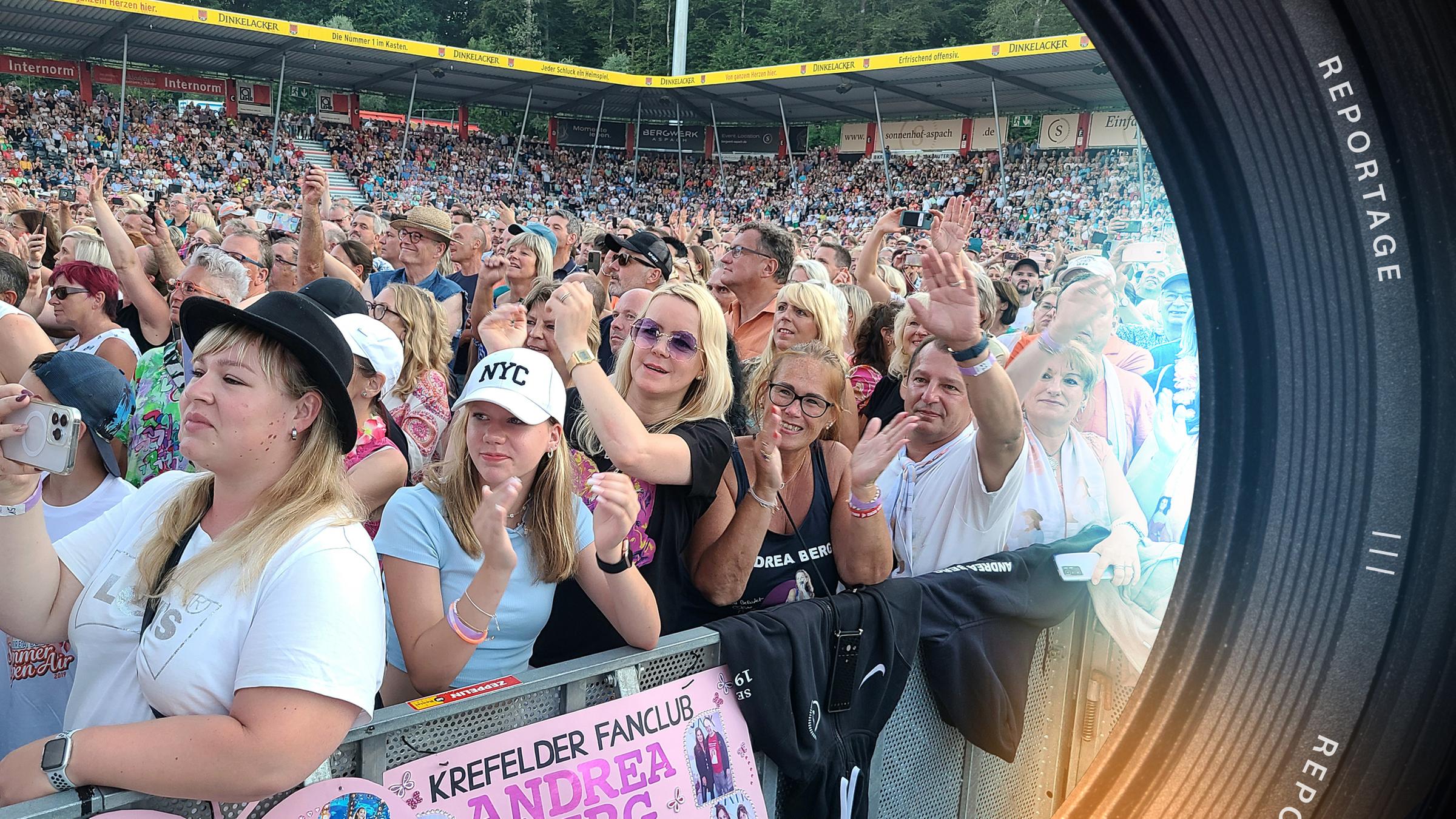 Blick auf Schlagerfans im Stadion. Im Vordergrund, an der Absperrung, stehen die leidenschaftlichen Schlagerfans Tanja Convent-Lorenz und ihre Tochter Leia.