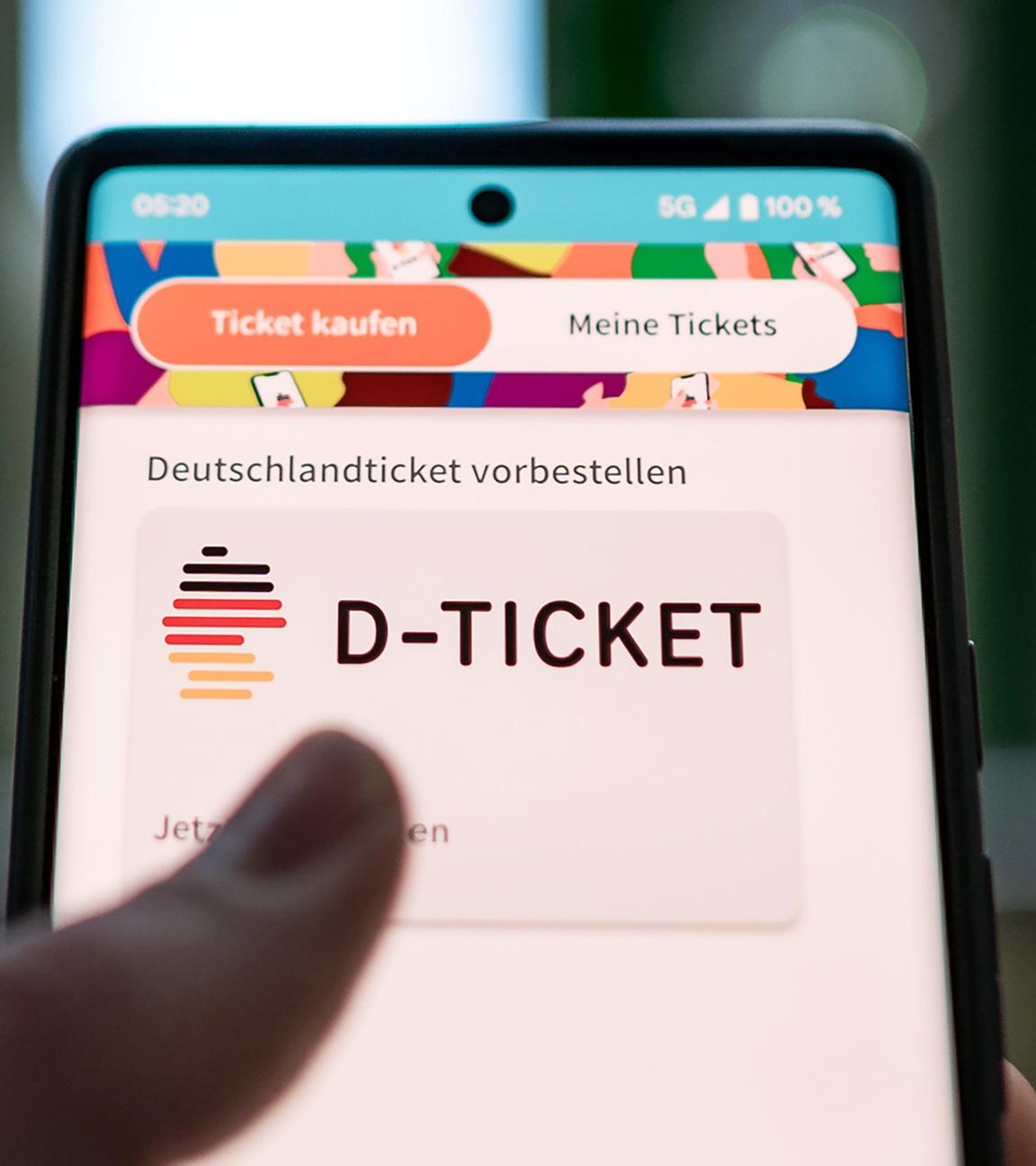 Ein Mann kauft Deutschlandticket per Handy