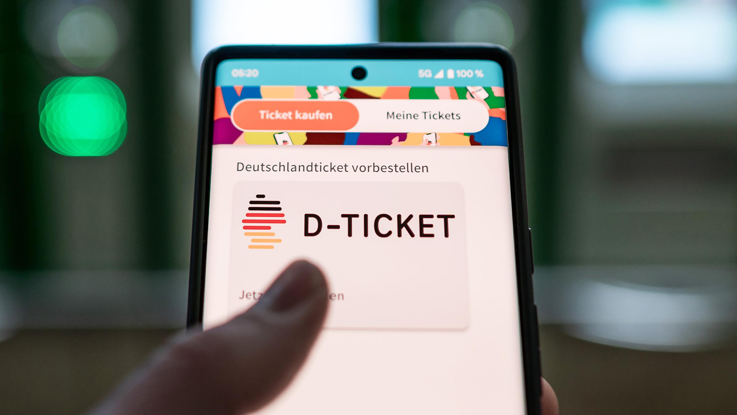 Ein Mann kauft Deutschlandticket per Handy