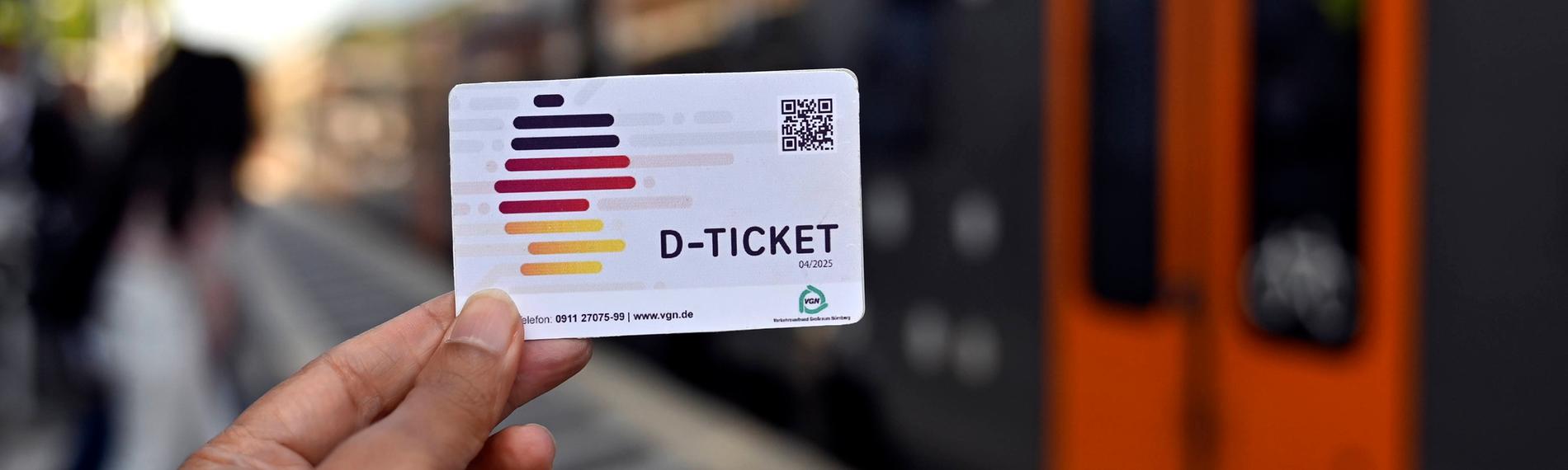 Eine Person hält das Deutschlandticket in der Hand.