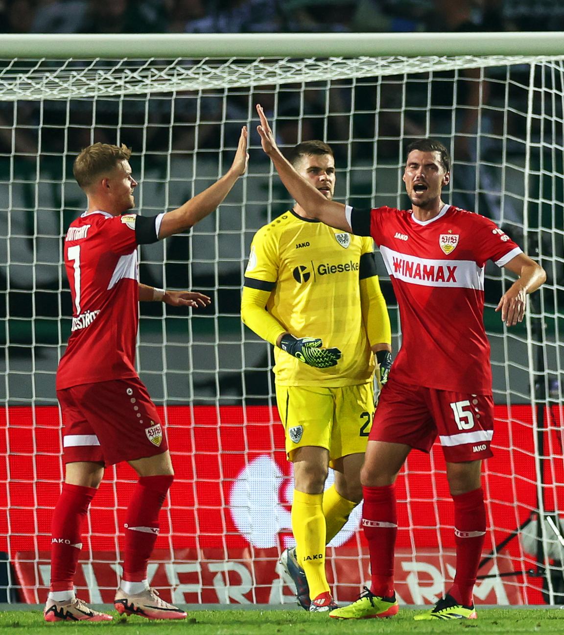 DFB-Pokal: Zwei VfB-Spieler klatschen sich nach einem Torerfolg in Münster vor dem Tor ab.