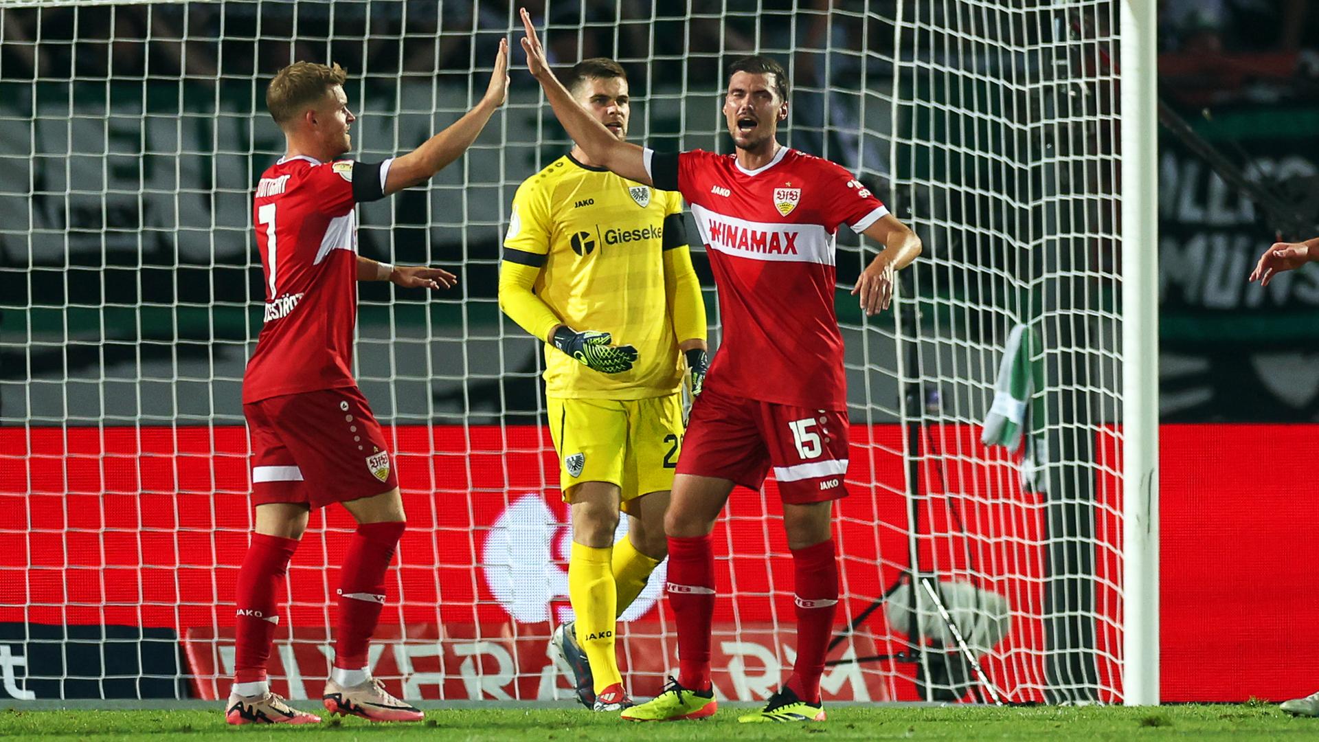 DFB-Pokal: Zwei VfB-Spieler klatschen sich nach einem Torerfolg in Münster vor dem Tor ab.