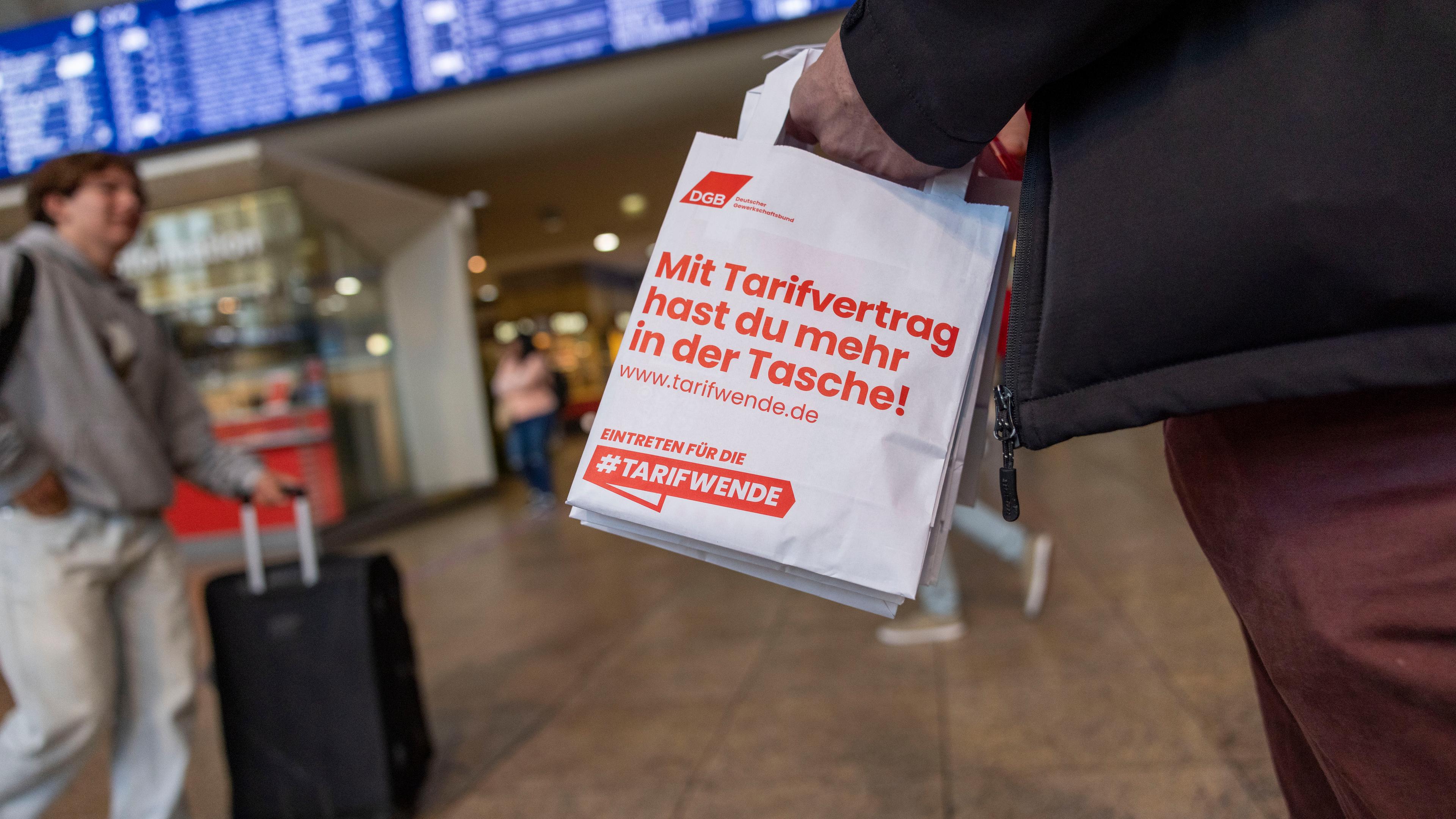  Nordrhein-Westfalen, Köln: Im Rahmen eines bundesweiten Aktionstags des Deutschen Gewerkschaftsbundes (DGB) verteilen Gewerkschaftsmitglieder im Hauptbahnhof Papiertüten mit der Aufschrift: ·Mit Tarifvertrag hast du mehr in der Tasche!·