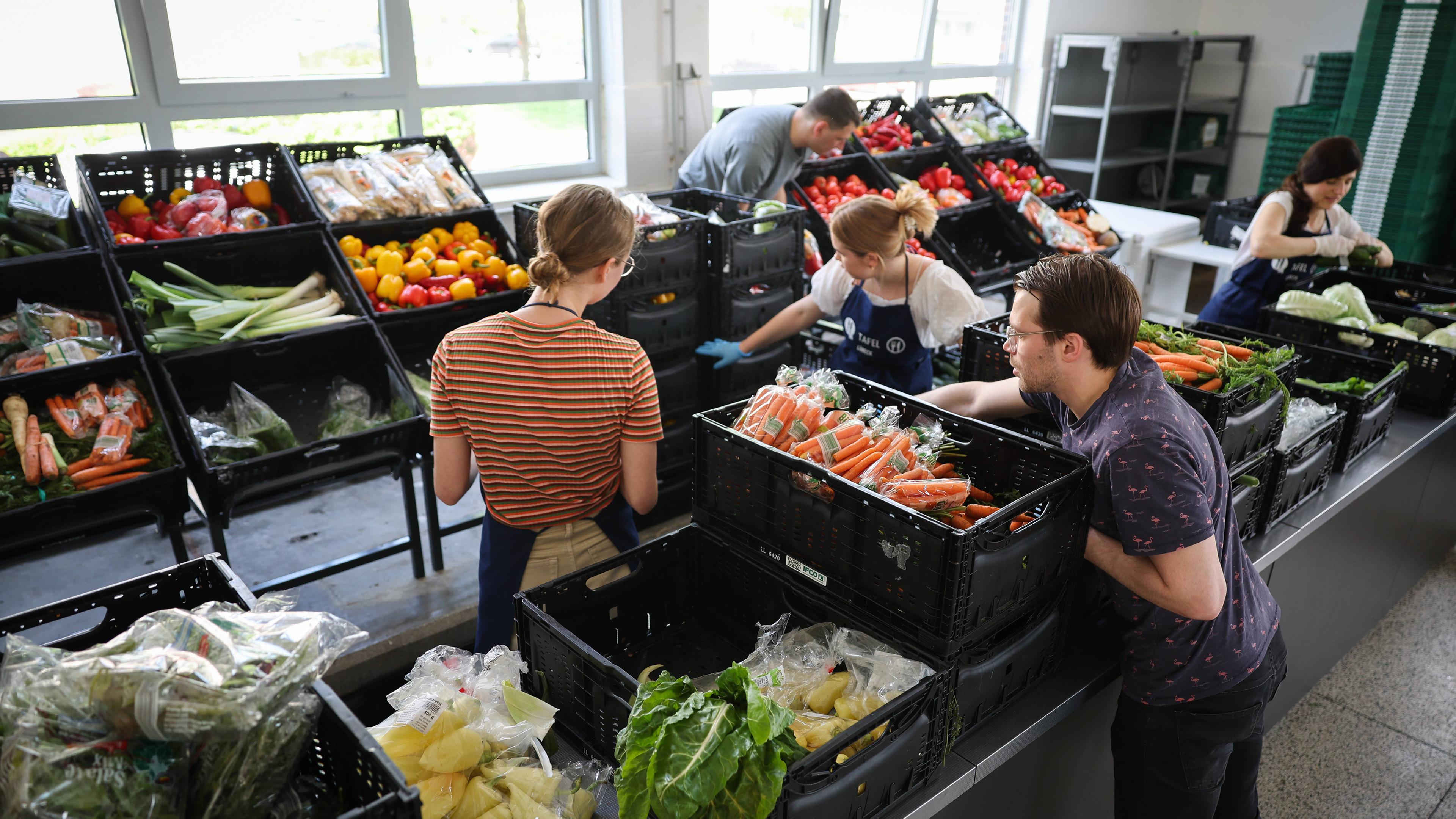 Ehrenamtliche Helferinnen und Helfer entpacken und sortieren Lebensmittel in der Ausgabestelle der Jungen Tafel am Kolberger Plat