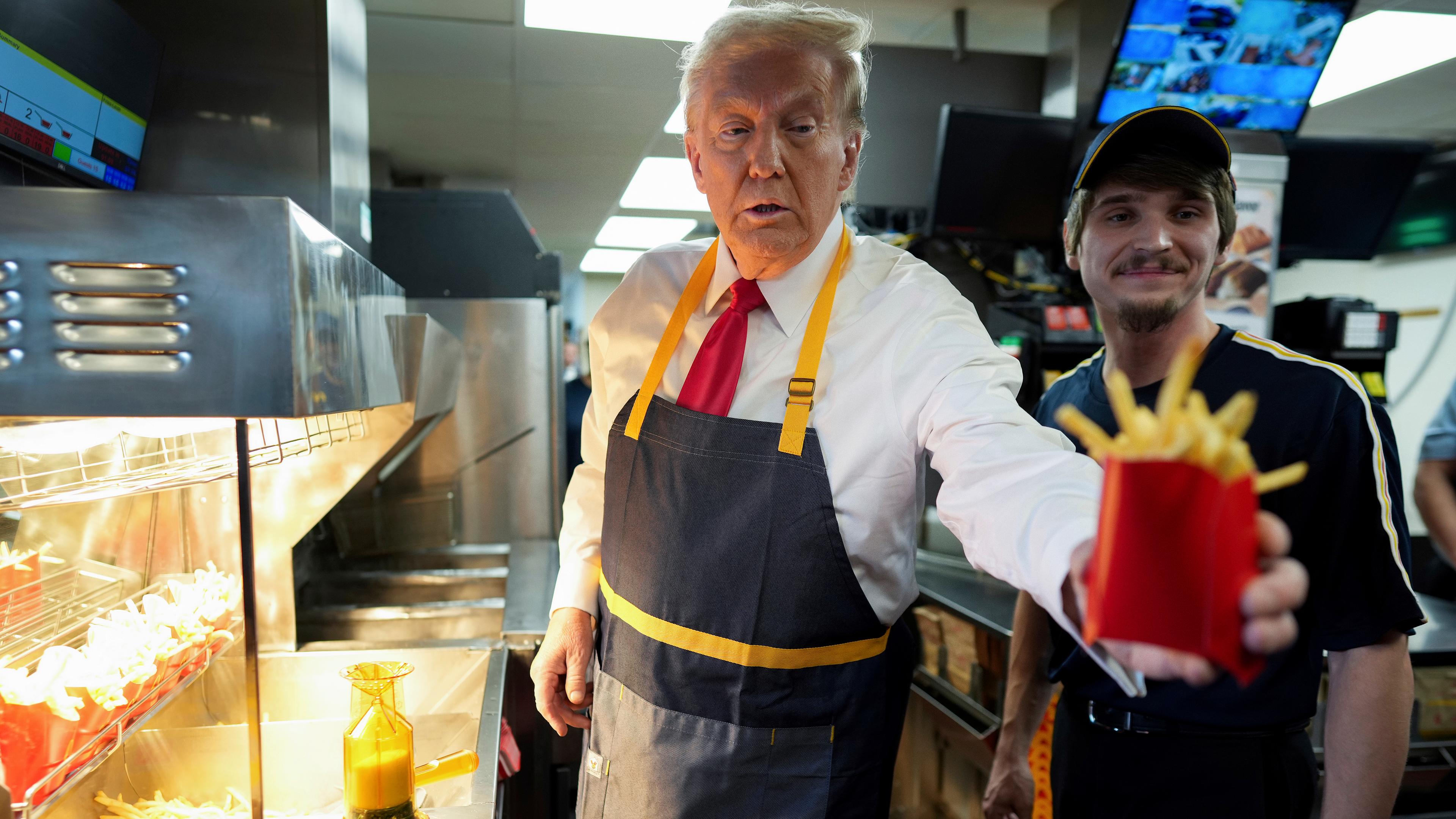 Donald Trump, Präsidentschaftskandidat der Republikaner und ehemaliger US-Präsident, gibt eine Pommes-Bestellung aus, nachdem er mit einem Angestellten während eines Besuchs bei McDonald's in Feasterville-Trevose zusammengearbeitet hat.