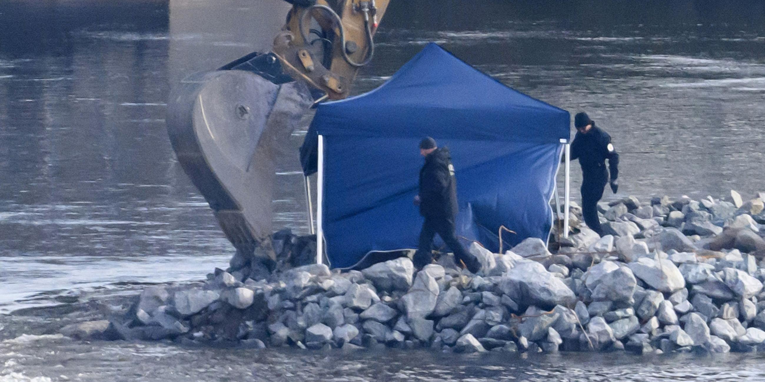 Mitarbeiter der Kampfmittelbeseitigung (KMBD) laufen vor Beginn der Entschärfung einer Weltkriegsbombe an der Fundstelle auf der Baustraße für den Abriss der Carolabrücke entlang.