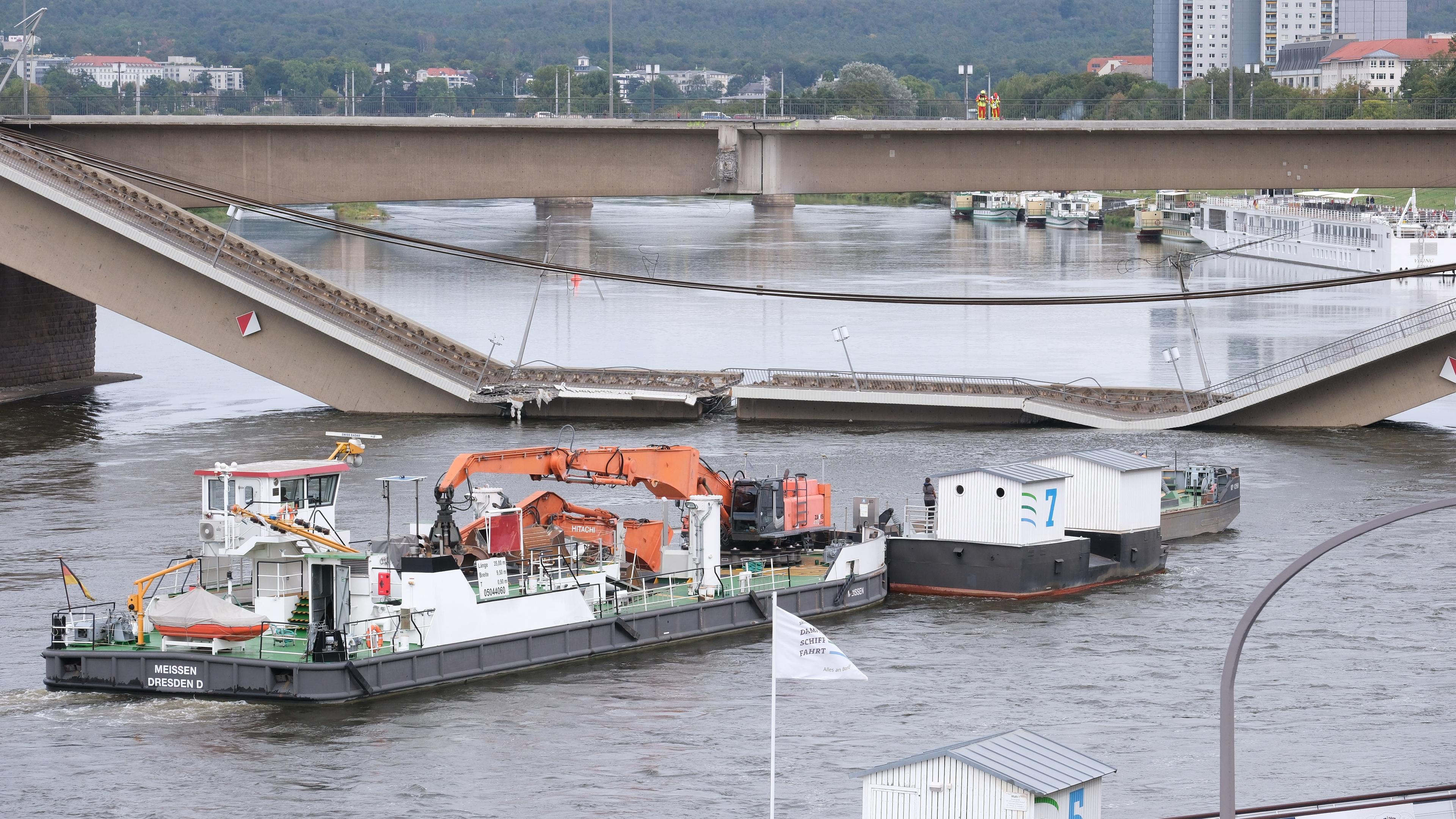 12.09.2024, Sachsen, Dresden: Ein Bootsanleger wird aus dem Umfeld der Carolabrücke bewegt.