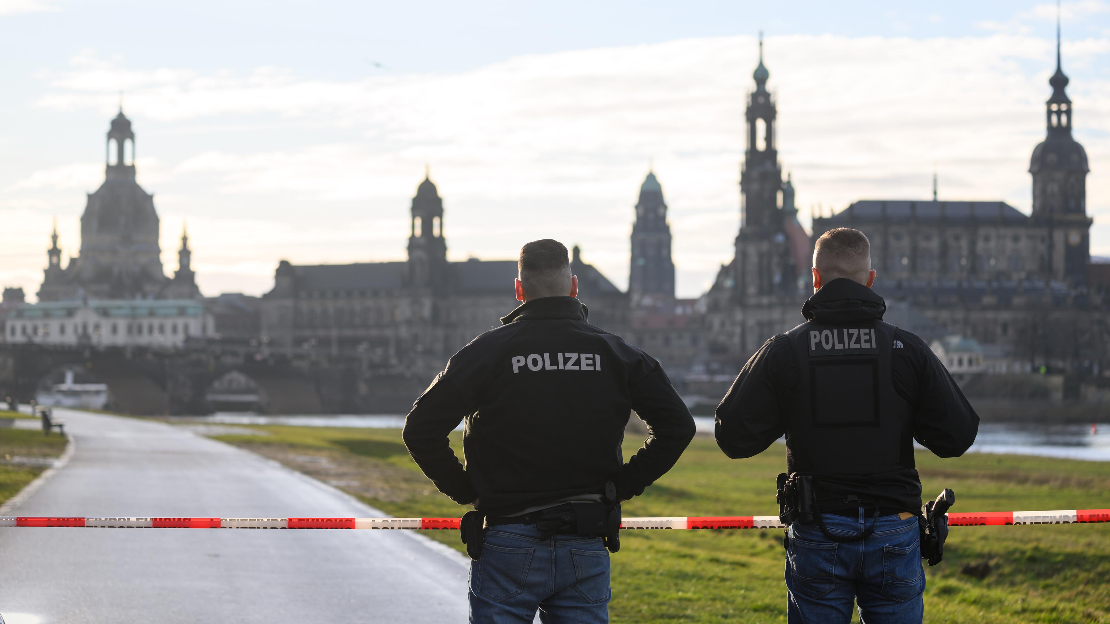 Sachsen, Dresden: Polizisten sperren während einer Evakuierung der Innenstadt den Elberadweg gegenüber der Altstadtkulisse.