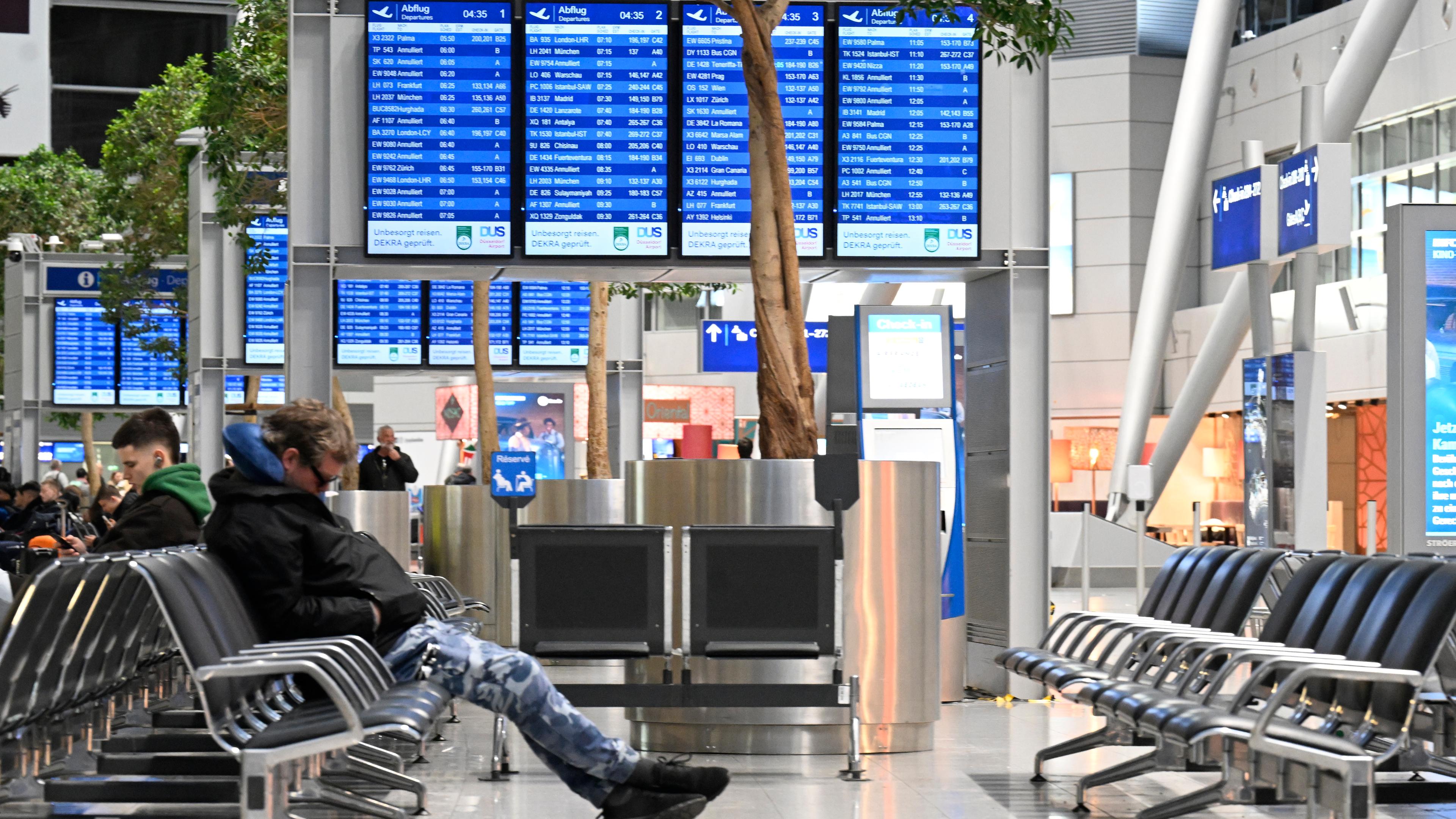 Reisende warten auf ihren Flug, nachdem Beschäftigte der Abfertigung des Flughafens seit heute morgen für bessere Löhne streiken.