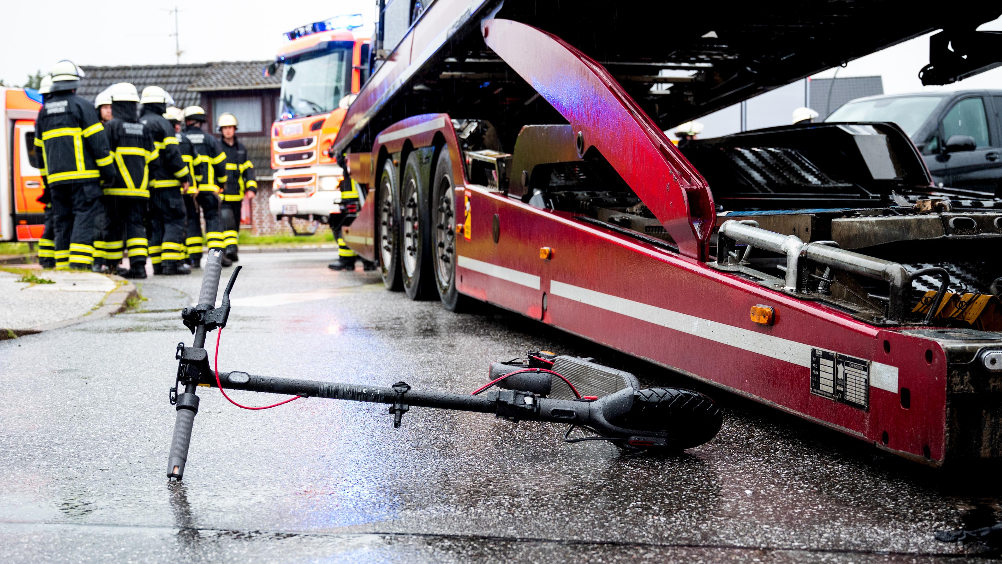  Ein E-Roller liegt an einer Unfallstelle neben einem Lastwagen. 