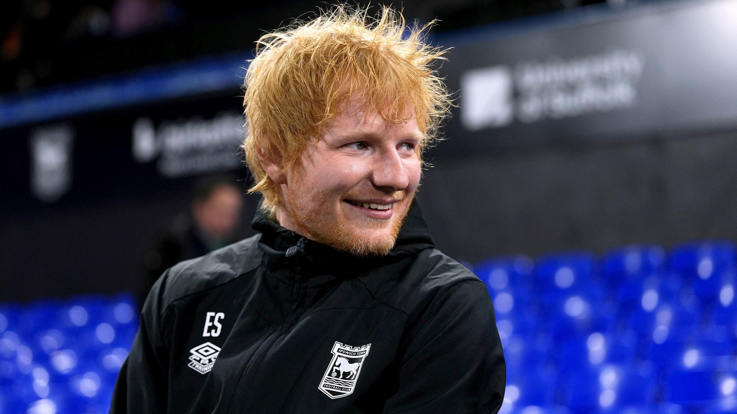 Der Sänger Ed Sheeran in Trainingsklamotten von dem Fußballverein Ipswich Town.