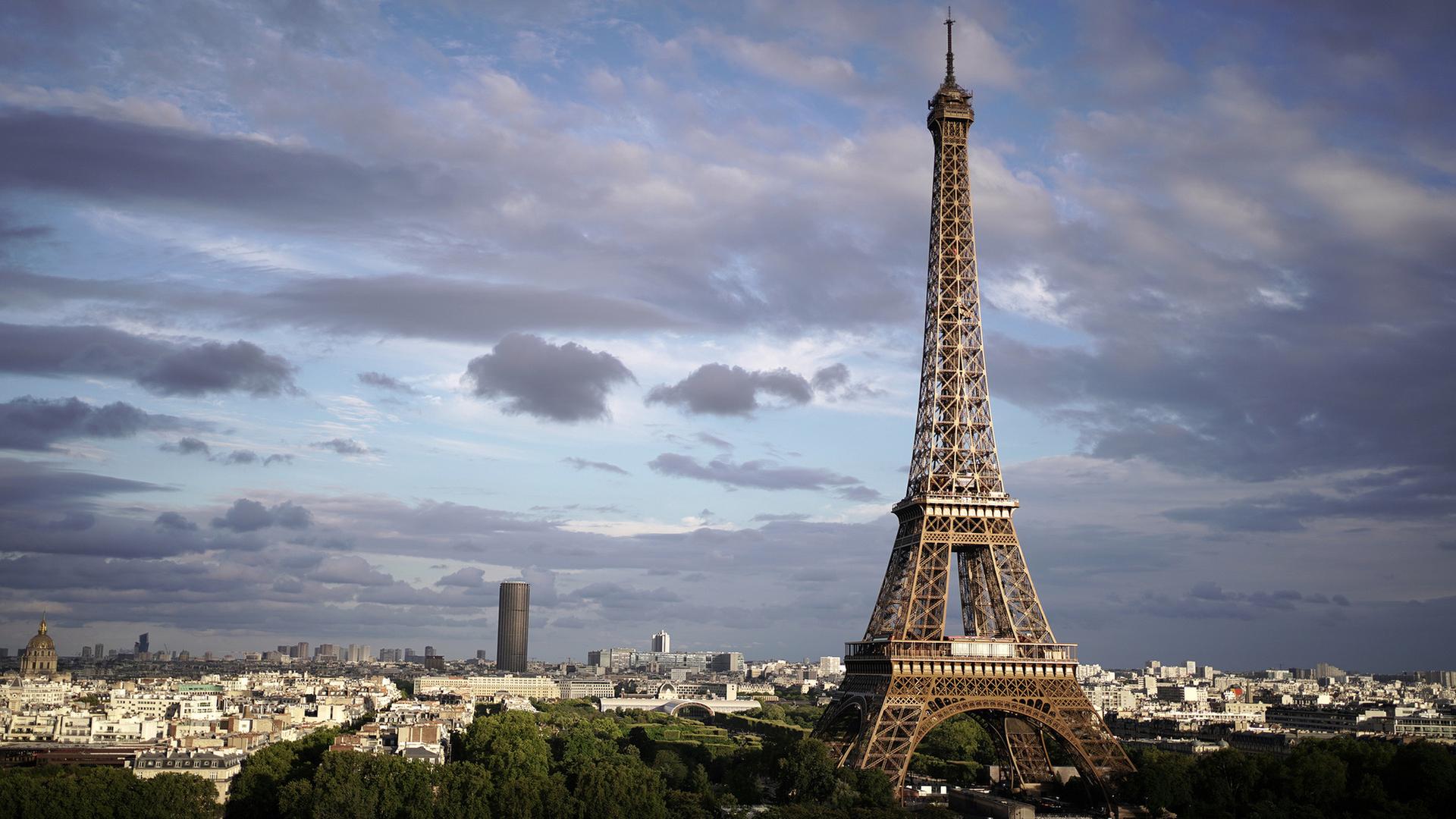 Blick über Paris bei Tag mit dem Eifelturm vor einem wolkenverhangenen Himmel