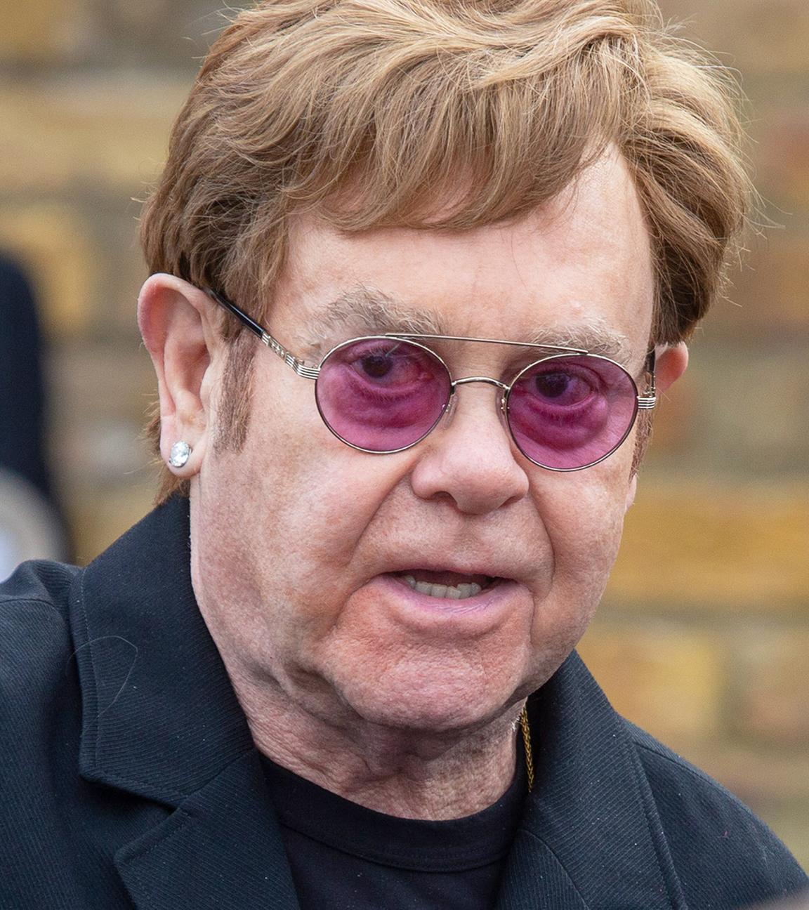 Der Sänger Elton John mit lila Sonnenbrille.