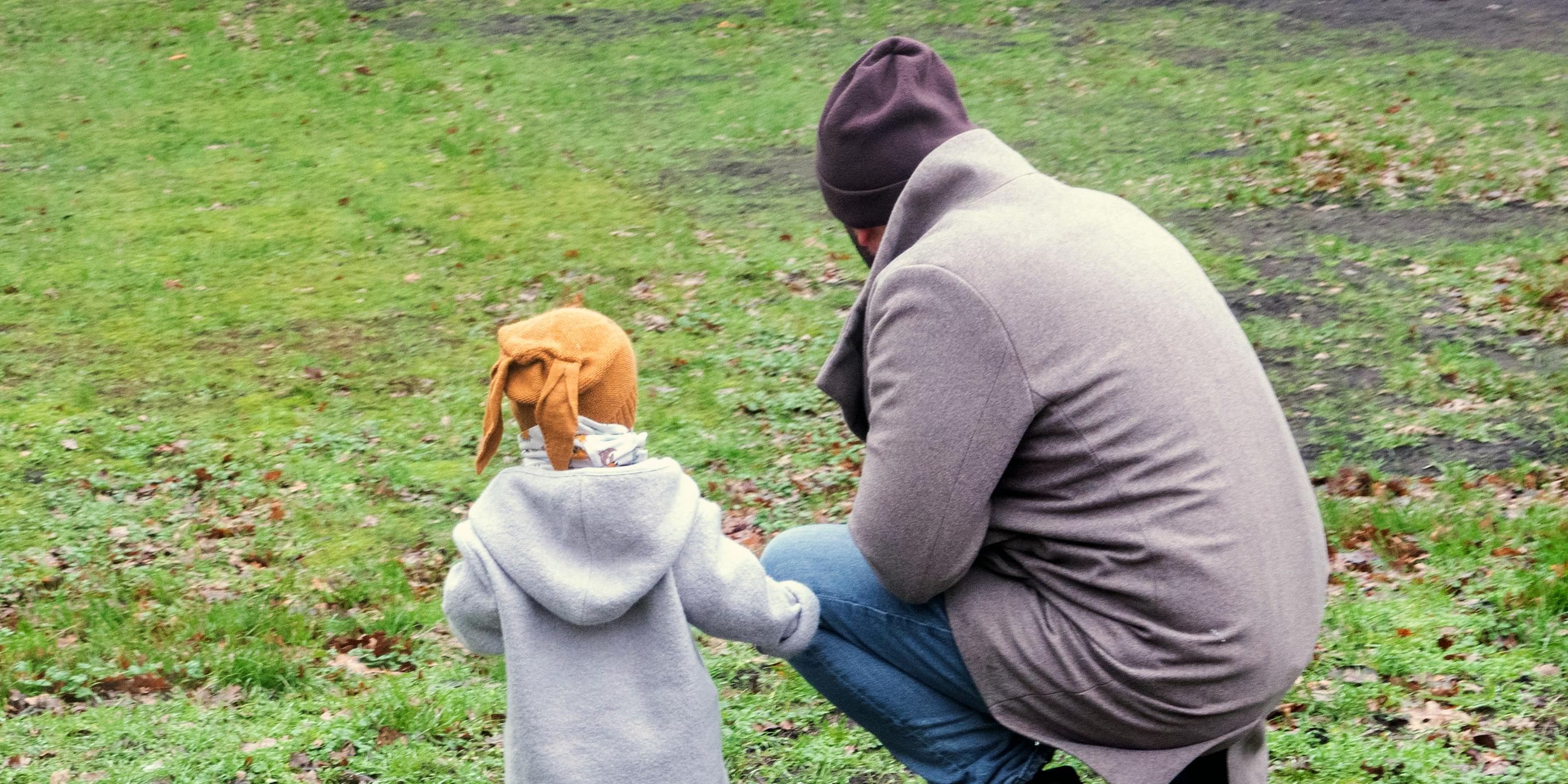 Ein Vater spielt mit seinem Kind in einem Park