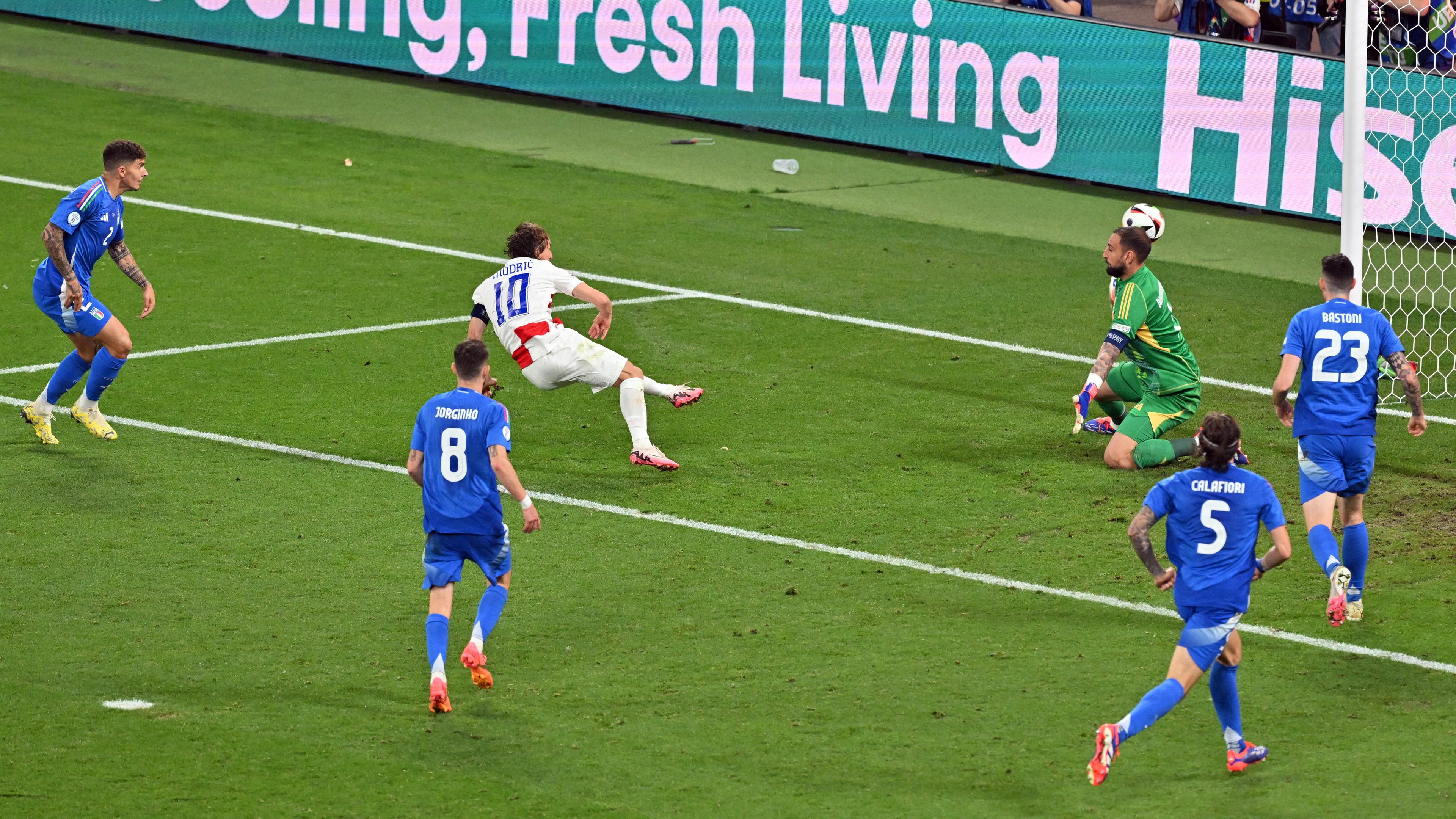 Kroatiens Luka Modric (l) erzielt das 1:0 gegen Italiens Torhüter Gianluigi Donnarumma (r).