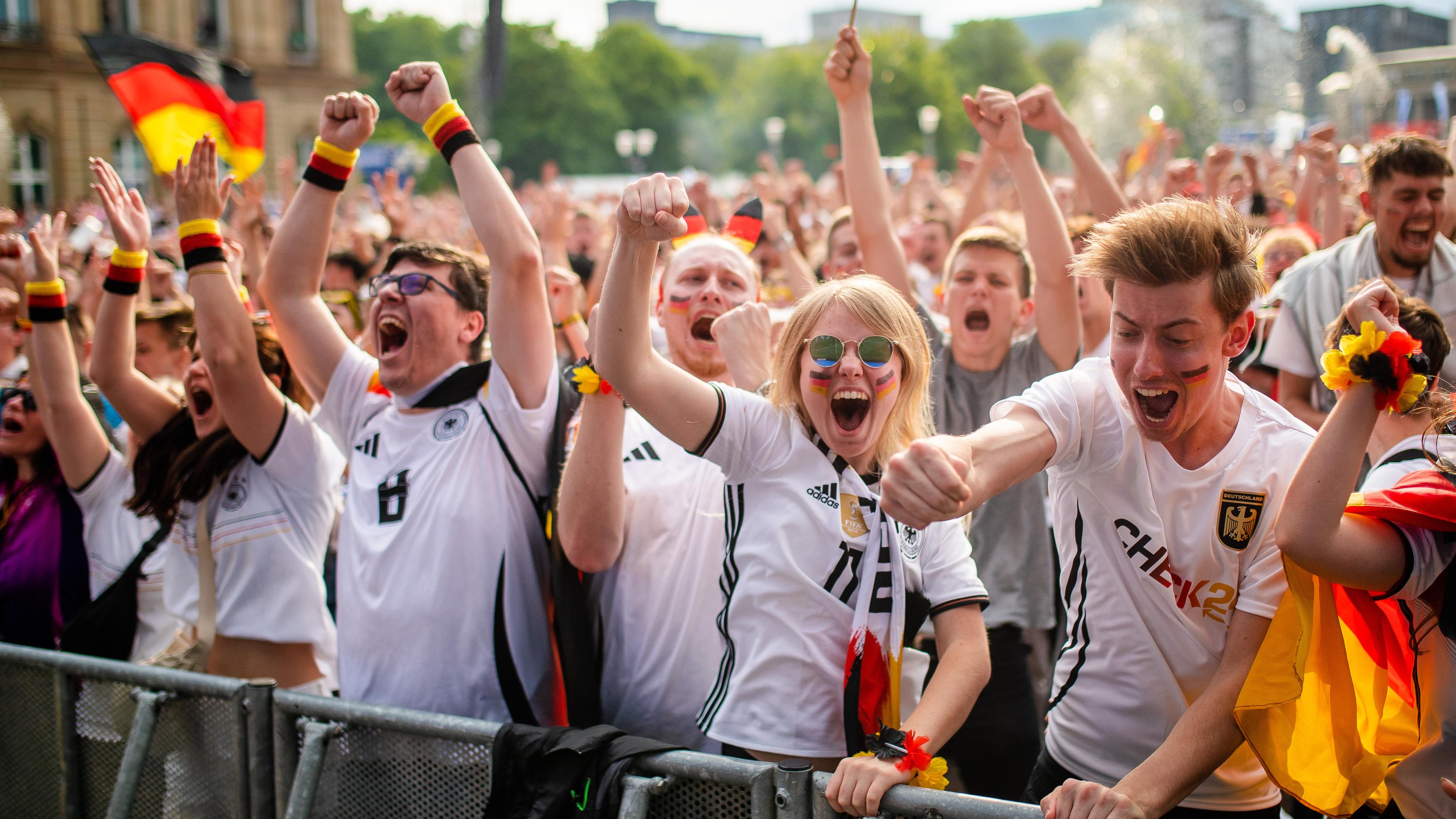 Deutschland-Fans freuen sich beim Public Viewing auf dem Schlossplatz über Deutschlands Treffer zum 1:0 Treffer.
