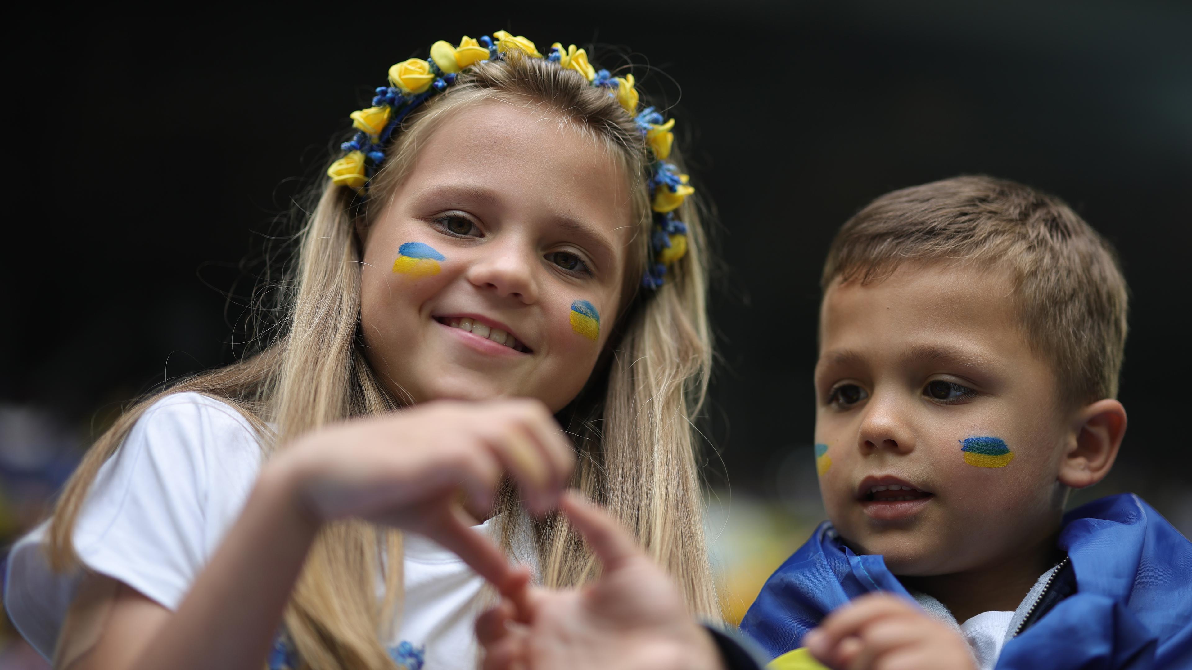 Junge ukrainische Fans zeigen vor dem Spiel ein Herz mit ihren Händen.