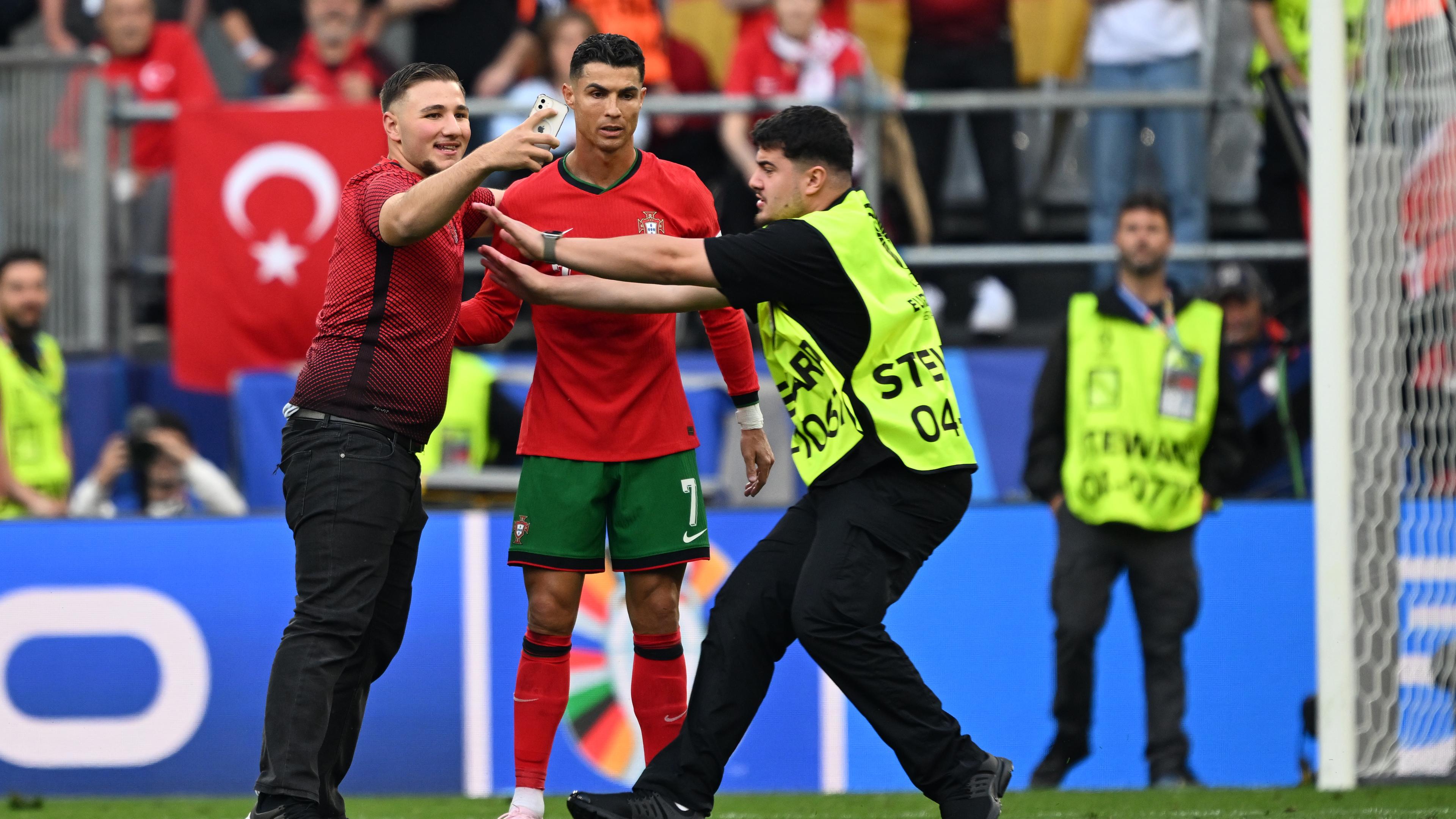 Ein Flitzer macht eine Selfie mit Portugals Cristiano Ronaldo während der Partie.